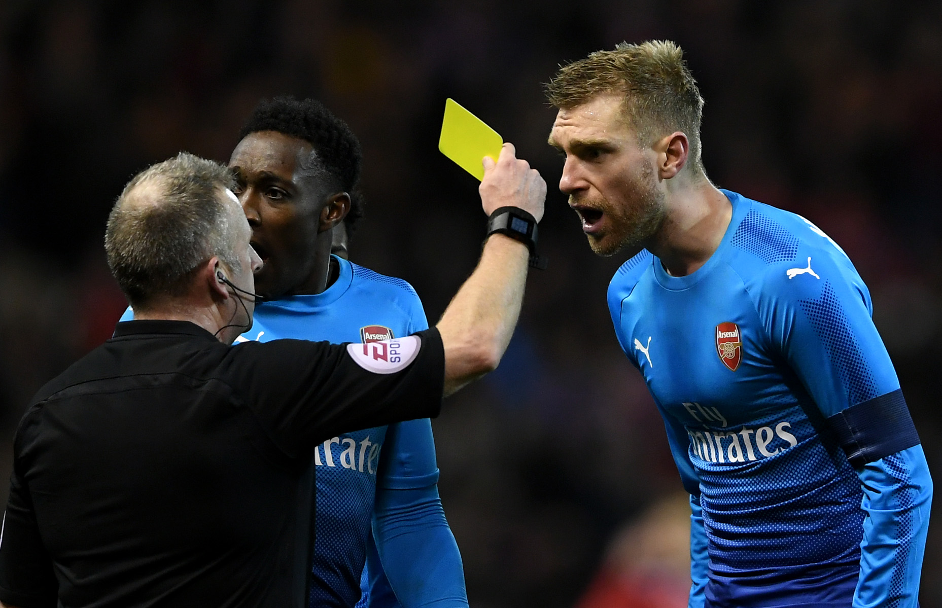 NOTTINGHAM, ENGLAND - JANUARY 07:  Per Mertesacker of Arsenal is shown the yellow card by referee Jonathan Moss after he awarded Nottingham Forest's fourth goal during The Emirates FA Cup Third Round match between Nottingham Forest and Arsenal at City Ground on January 7, 2018 in Nottingham, England.  (Photo by Laurence Griffiths/Getty Images)