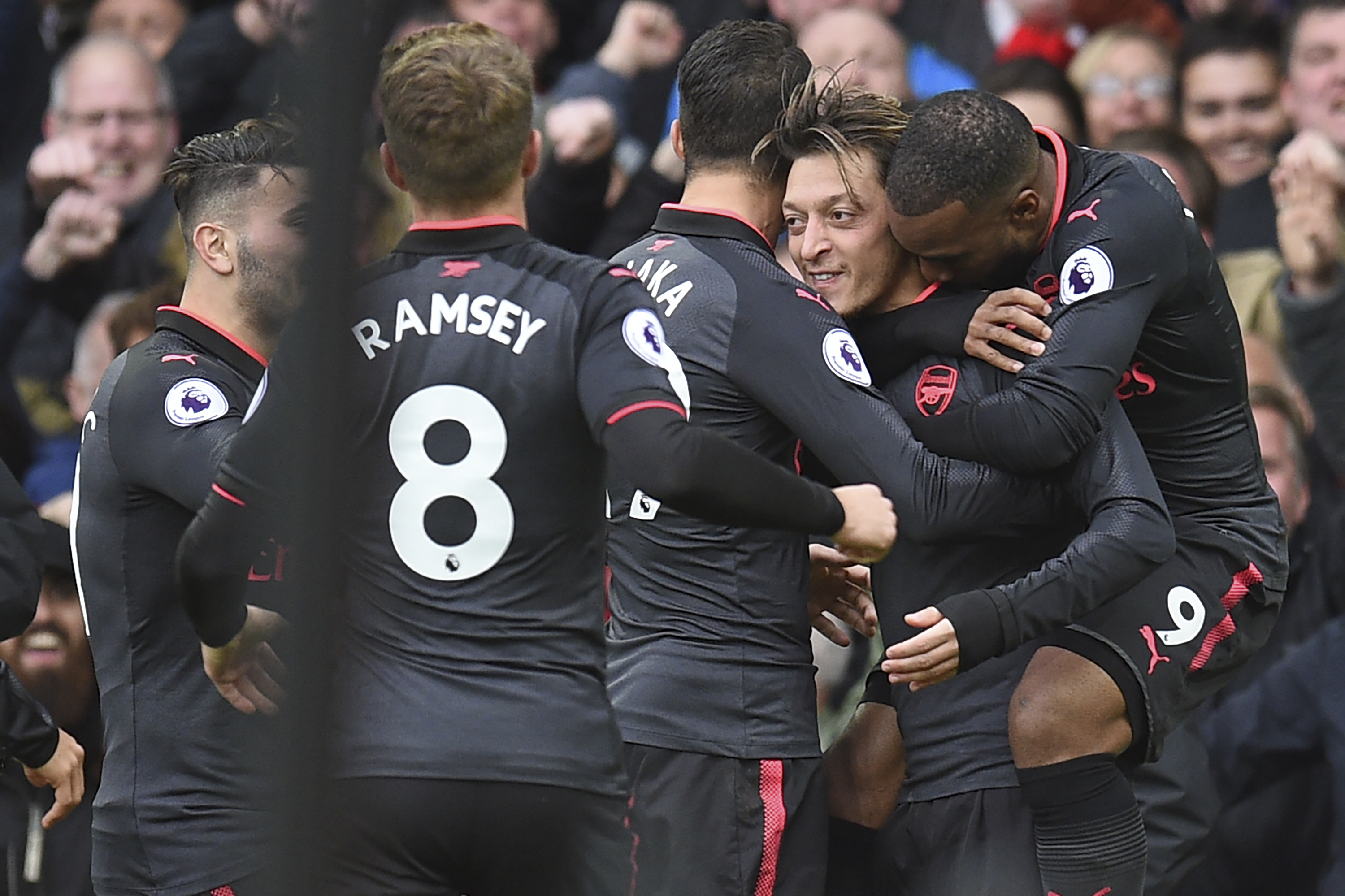 Arsenal's German midfielder Mesut Ozil (2R) celebrates scoring their second goal during the English Premier League football match between Everton and Arsenal at Goodison Park in Liverpool, north west England on October 22, 2017. / AFP PHOTO / Oli SCARFF / RESTRICTED TO EDITORIAL USE. No use with unauthorized audio, video, data, fixture lists, club/league logos or 'live' services. Online in-match use limited to 75 images, no video emulation. No use in betting, games or single club/league/player publications.  /         (Photo credit should read OLI SCARFF/AFP/Getty Images)