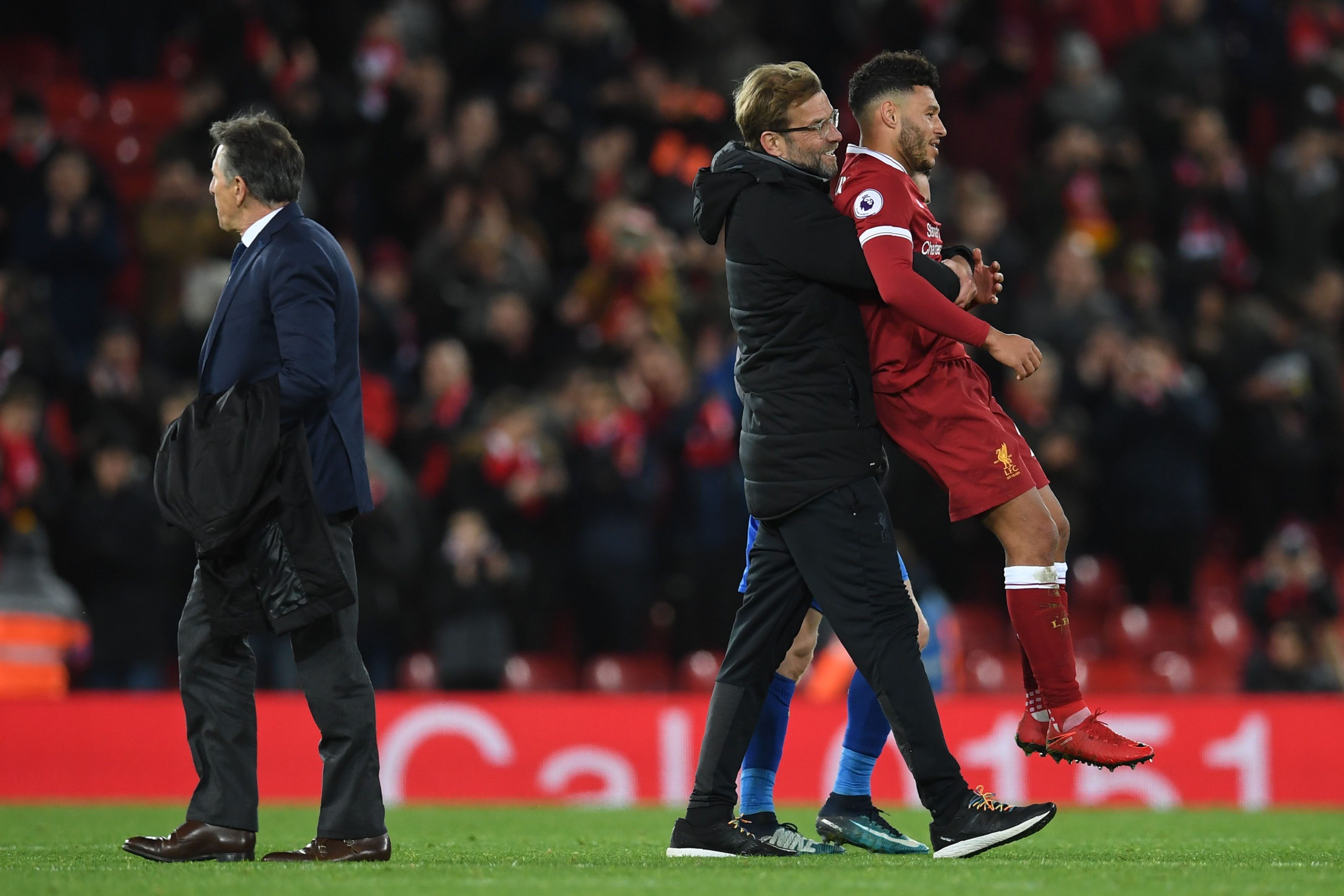 Liverpool's German manager Jurgen Klopp (C) congratulates Liverpool's English midfielder Alex Oxlade-Chamberlain (R) as Leicester City's French manager Claude Puel walks after the English Premier League football match between Liverpool and Leicester at Anfield in Liverpool, north west England on December 30, 2017. / AFP PHOTO / Paul ELLIS / RESTRICTED TO EDITORIAL USE. No use with unauthorized audio, video, data, fixture lists, club/league logos or 'live' services. Online in-match use limited to 75 images, no video emulation. No use in betting, games or single club/league/player publications.  /         (Photo credit should read PAUL ELLIS/AFP/Getty Images)