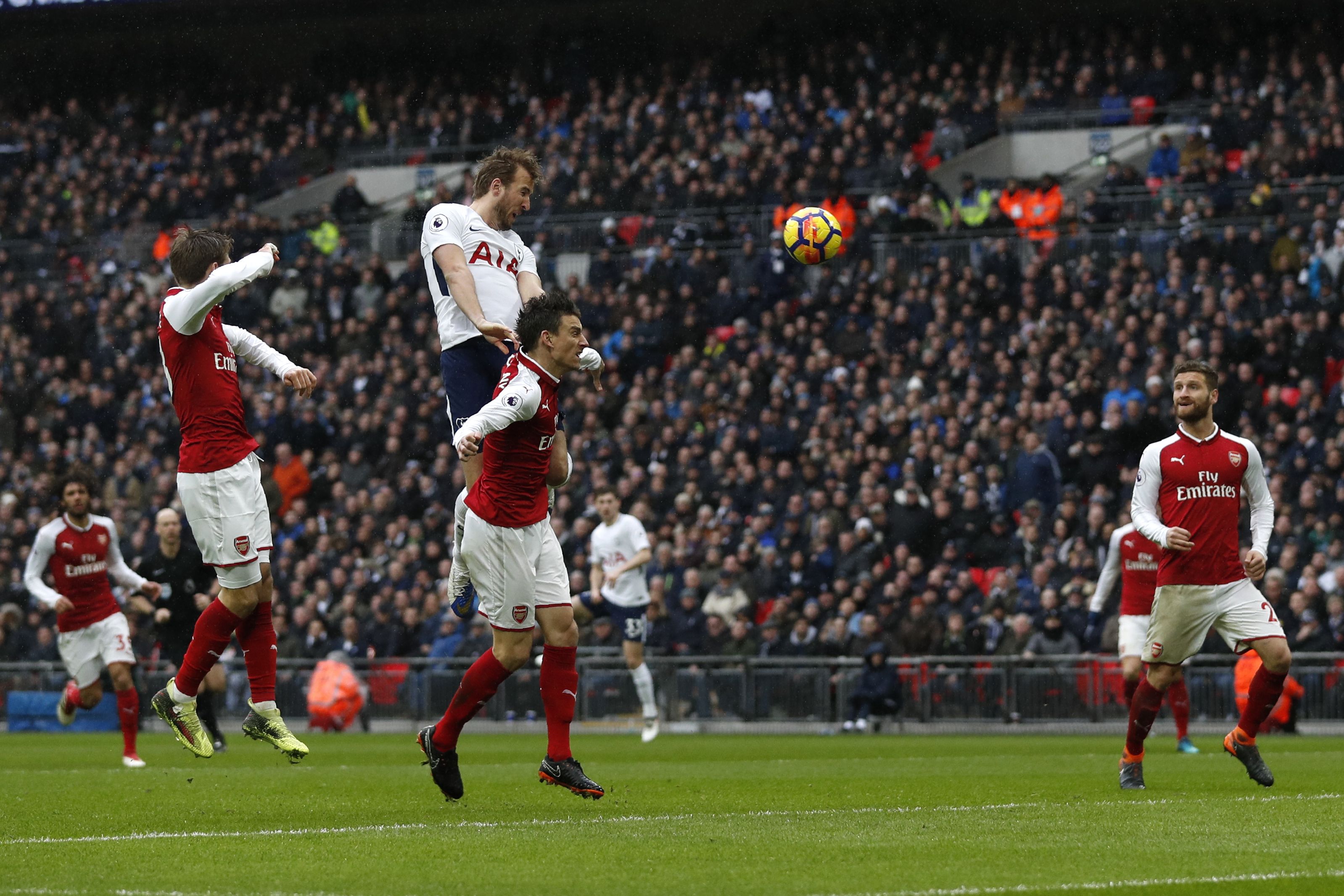 Tottenham Hotspur's English striker Harry Kane (2L) heads the ball to score the opening goal during the English Premier League football match between Tottenham Hotspur and Arsenal at Wembley Stadium in London, on February 10, 2018. / AFP PHOTO / Adrian DENNIS / RESTRICTED TO EDITORIAL USE. No use with unauthorized audio, video, data, fixture lists, club/league logos or 'live' services. Online in-match use limited to 75 images, no video emulation. No use in betting, games or single club/league/player publications.  /         (Photo credit should read ADRIAN DENNIS/AFP/Getty Images)