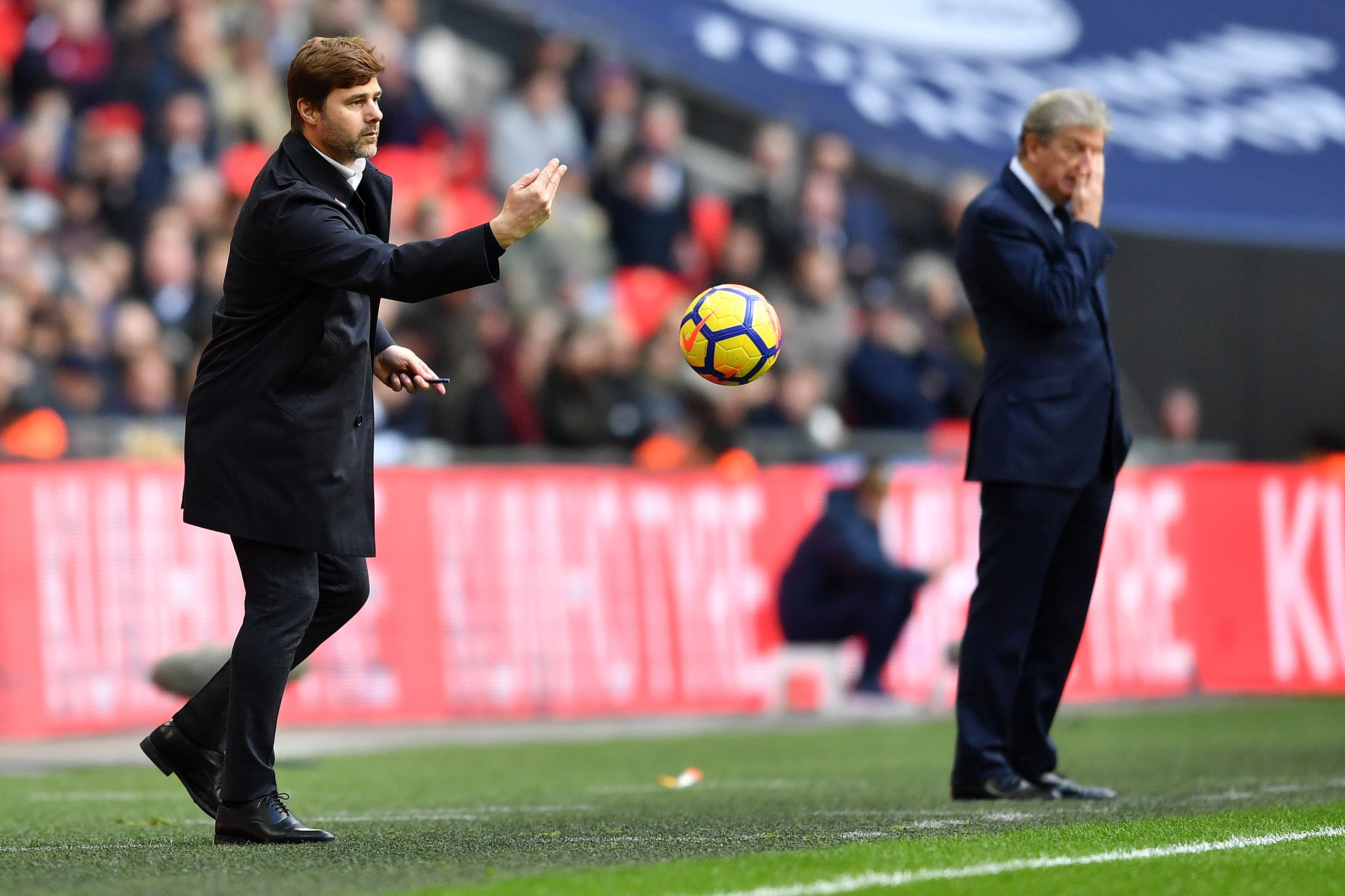 Tottenham Hotspur's Argentinian head coach Mauricio Pochettino (L) throws the ball back in to play as Crystal Palace's English manager Roy Hodgson reacts during the English Premier League football match between Tottenham Hotspur and Crystal Palace at Wembley Stadium in London, on November 5, 2017. / AFP PHOTO / Ben STANSALL / RESTRICTED TO EDITORIAL USE. No use with unauthorized audio, video, data, fixture lists, club/league logos or 'live' services. Online in-match use limited to 75 images, no video emulation. No use in betting, games or single club/league/player publications.  /         (Photo credit should read BEN STANSALL/AFP/Getty Images)