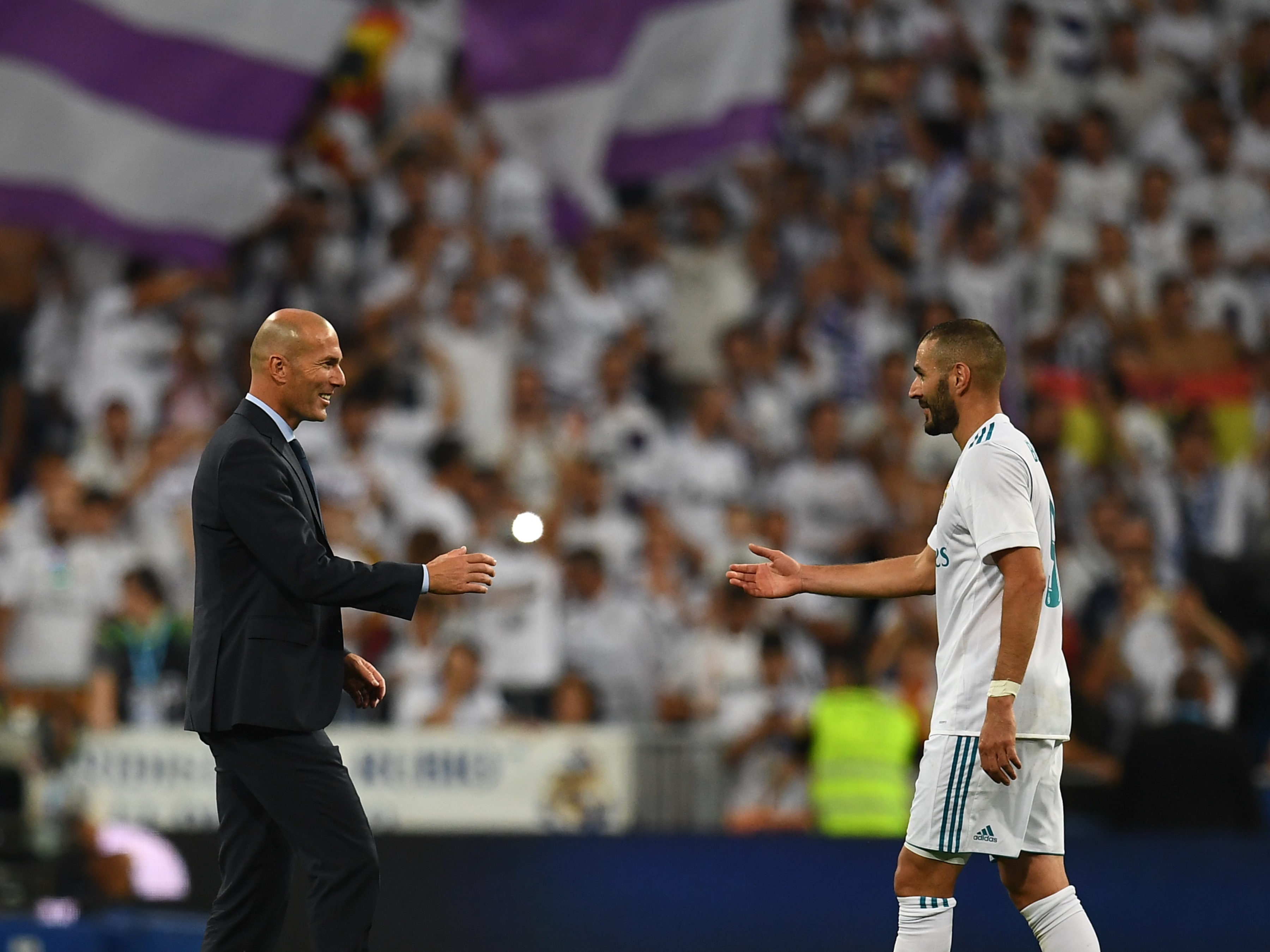 Real Madrid's French coach Zinedine Zidane (L) and Real Madrid's French forward Karim Benzema congratulate each other as they celebrate their Supercup after winning the second leg of the Spanish Supercup football match Real Madrid vs FC Barcelona at the Santiago Bernabeu stadium in Madrid, on August 16, 2017. / AFP PHOTO / GABRIEL BOUYS        (Photo credit should read GABRIEL BOUYS/AFP/Getty Images)