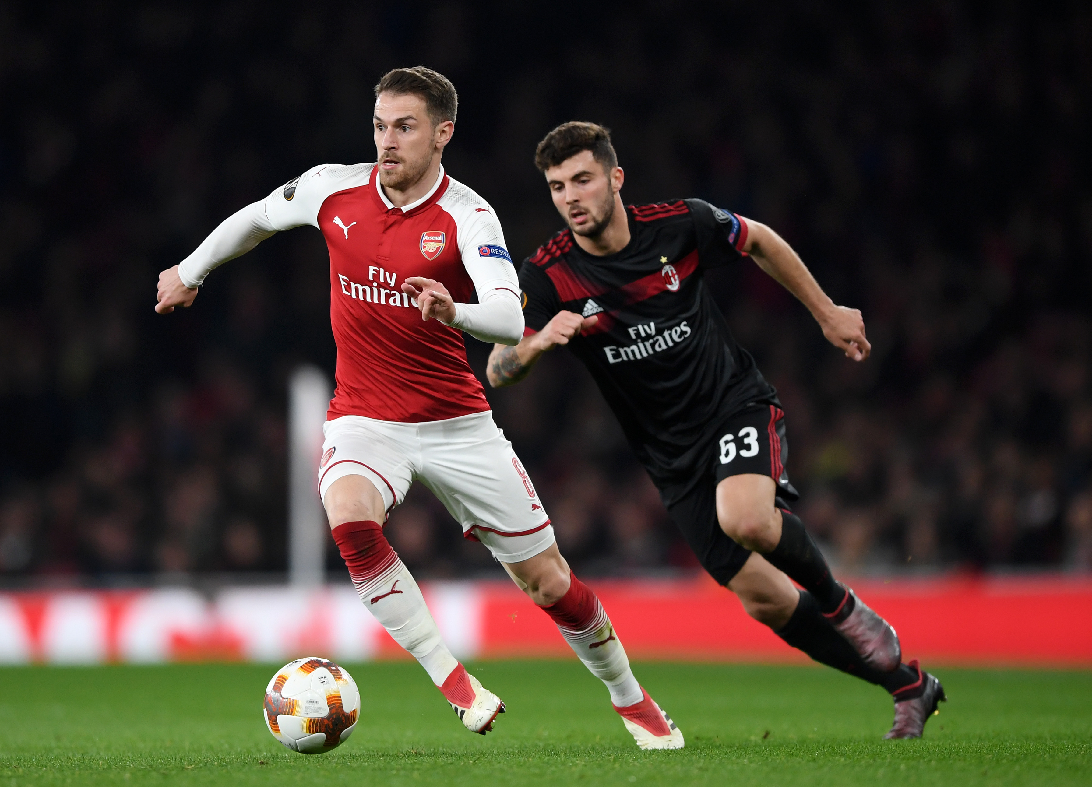 LONDON, ENGLAND - MARCH 15:  Aaron Ramsey of Arsenal breaks from Patrick Cutrone of AC Milan during the UEFA Europa League Round of 16 Second Leg match between Arsenal and AC Milan at Emirates Stadium on March 15, 2018 in London, England.  (Photo by Shaun Botterill/Getty Images)