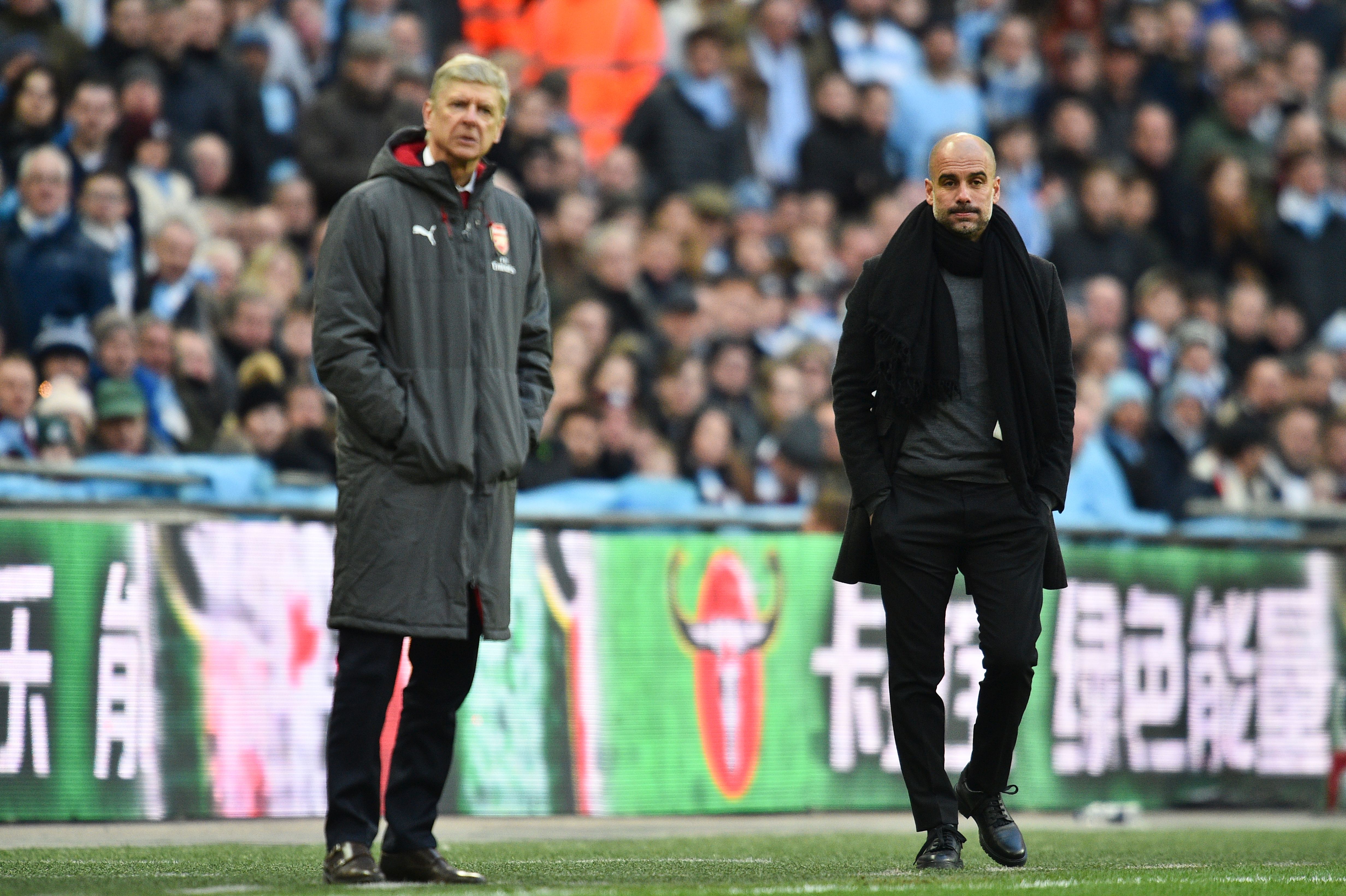 Manchester City's Spanish manager Pep Guardiola (R) and Arsenal's French manager Arsene Wenger (L) watch from the touchline during the English League Cup final football match between Manchester City and Arsenal at Wembley stadium in north London on February 25, 2018. / AFP PHOTO / Glyn KIRK / RESTRICTED TO EDITORIAL USE. No use with unauthorized audio, video, data, fixture lists, club/league logos or 'live' services. Online in-match use limited to 75 images, no video emulation. No use in betting, games or single club/league/player publications.  /         (Photo credit should read GLYN KIRK/AFP/Getty Images)