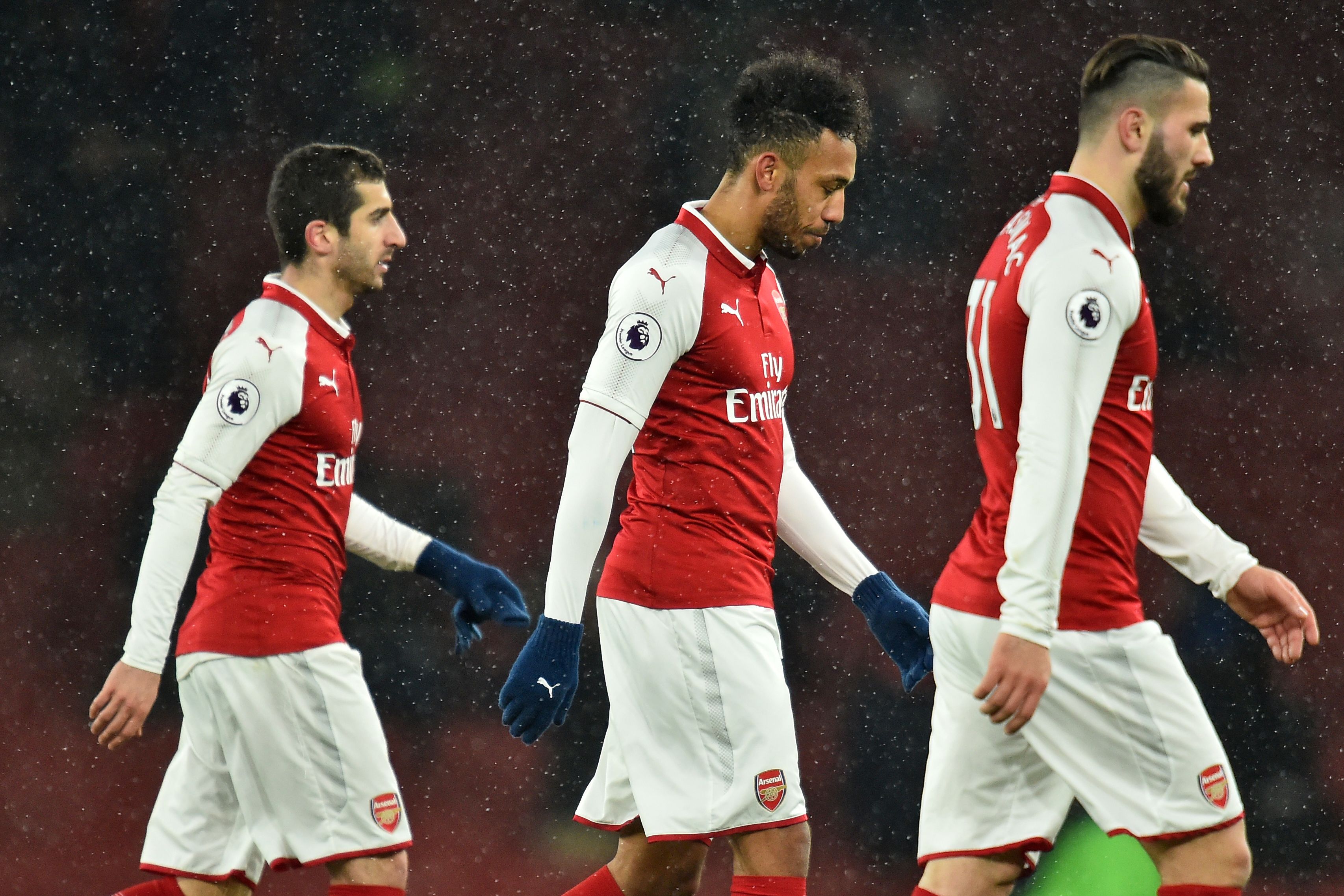 Arsenal's Armenian midfielder Henrikh Mkhitaryan (L), Arsenal's Gabonese striker Pierre-Emerick Aubameyang (C) and Arsenal's German-born Bosnian defender Sead Kolasinac (R) leave the pitch after the English Premier League football match between Arsenal and Manchester City at the Emirates Stadium in London on March 1, 2018. 
Manchester City won the game 3-0.  / AFP PHOTO / Glyn KIRK / RESTRICTED TO EDITORIAL USE. No use with unauthorized audio, video, data, fixture lists, club/league logos or 'live' services. Online in-match use limited to 75 images, no video emulation. No use in betting, games or single club/league/player publications.  /         (Photo credit should read GLYN KIRK/AFP/Getty Images)