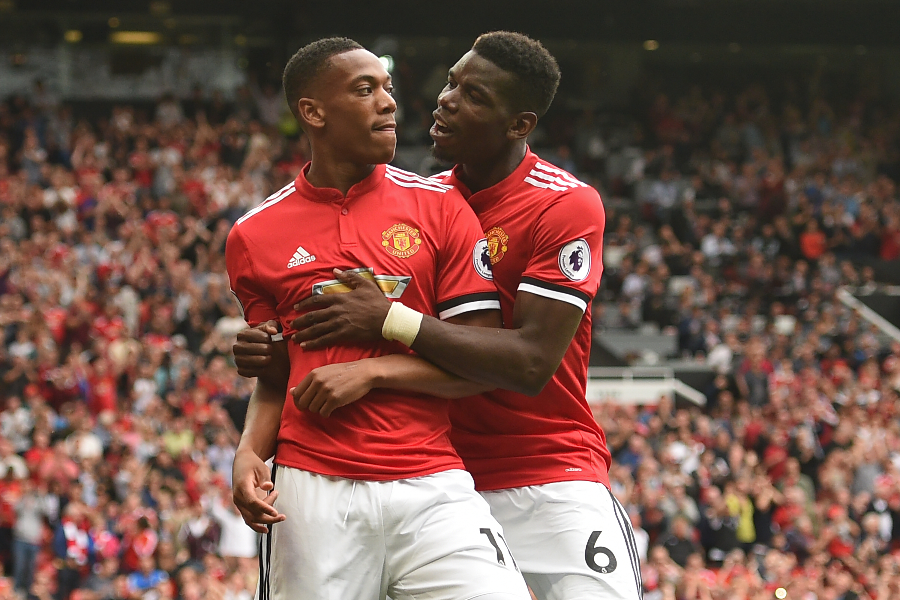 Manchester United's French striker Anthony Martial (L) celebrates with Manchester United's French midfielder Paul Pogba after scoring their third goal during the English Premier League football match between Manchester United and West Ham United at Old Trafford in Manchester, north west England, on August 13, 2017.
Manchester United won the game 4-0. / AFP PHOTO / Oli SCARFF / RESTRICTED TO EDITORIAL USE. No use with unauthorized audio, video, data, fixture lists, club/league logos or 'live' services. Online in-match use limited to 75 images, no video emulation. No use in betting, games or single club/league/player publications.  /         (Photo credit should read OLI SCARFF/AFP/Getty Images)