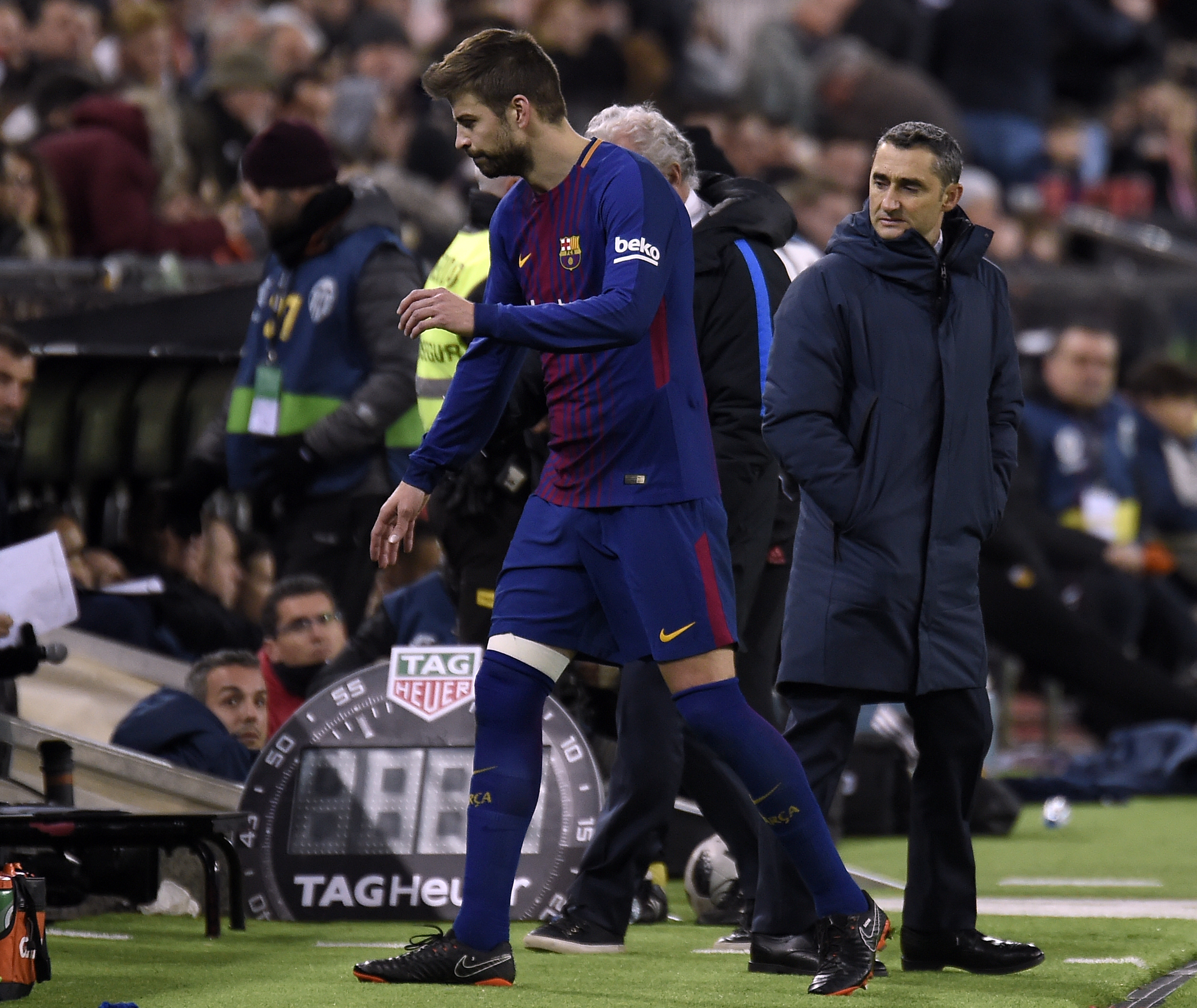 Barcelona's Spanish defender Gerard Pique (L) walks past Barcelona's Spanish coach Ernesto Valverde (R) as he leaves the field during the Spanish 'Copa del Rey' (King's cup) second leg semi-final football match between Valencia CF and FC Barcelona at the Mestalla stadium in Valencia on February 8, 2018. / AFP PHOTO / JOSE JORDAN        (Photo credit should read JOSE JORDAN/AFP/Getty Images)
