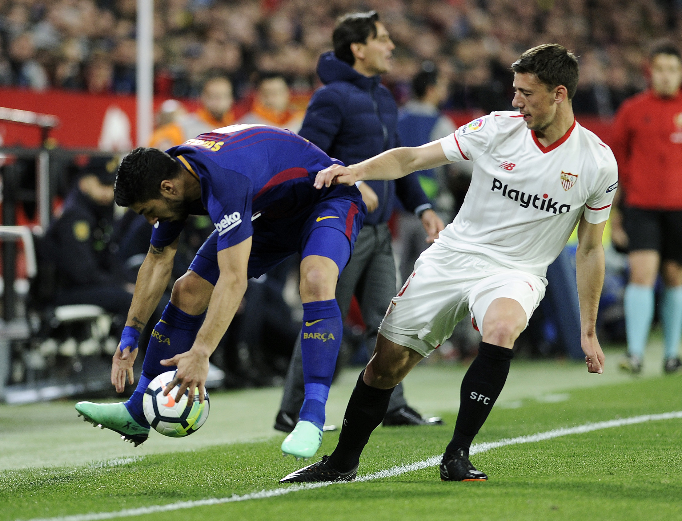 Barcelona's Uruguayan forward Luis Suarez (L) fights for the ball with Sevilla's French defender Clement Lenglet during the Spanish League football match between Sevilla FC and FC Barcelona at the Ramon Sanchez Pizjuan stadium on March 31, 2018. / AFP PHOTO / Cristina Quicler        (Photo credit should read CRISTINA QUICLER/AFP/Getty Images)