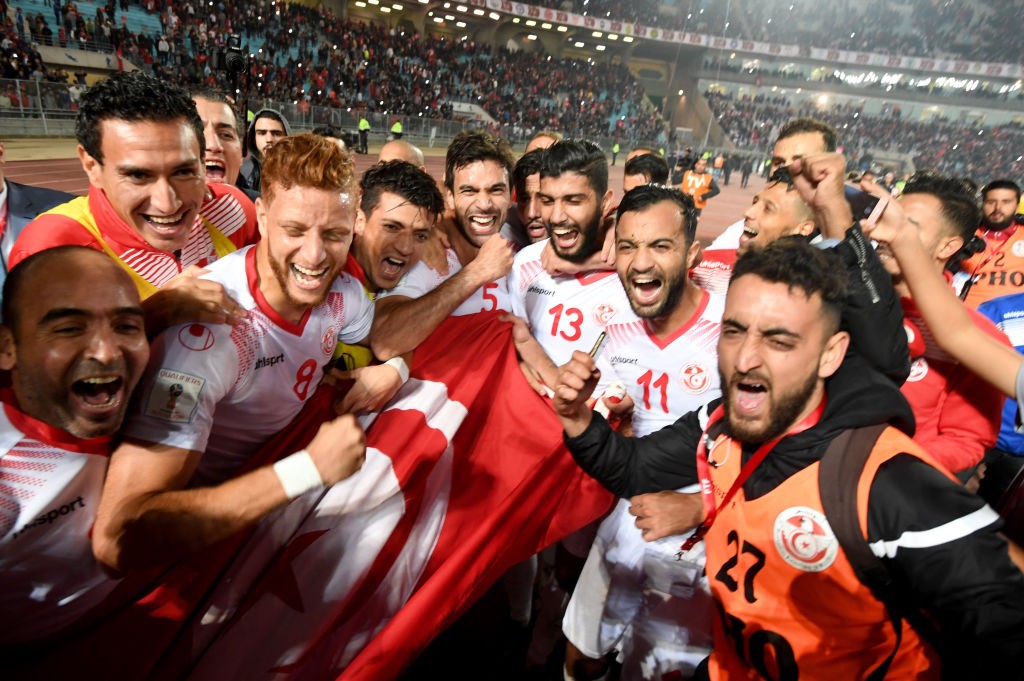 Players of the Tunisian national football team celebrate with their national flag after qualifying for the 2018 World Cup finals after drawing their qualifiers match against Libya at the Rades Olympic Stadium in the capital Tunis on November 11, 2017. / AFP PHOTO / FETHI BELAID (Photo credit should read FETHI BELAID/AFP/Getty Images)