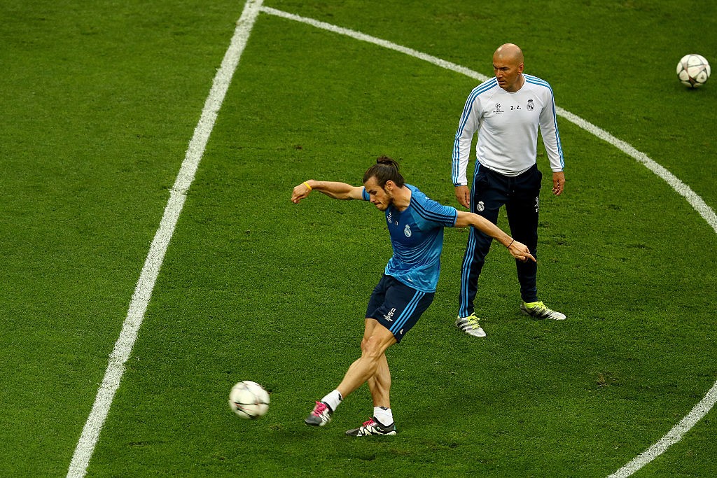 MILAN, ITALY - MAY 27: Gareth Bale of Real Madrid has a shot on goal as Head coach Zinedine Zidane looks on during a Real Madrid training session on the eve of the UEFA Champions League Final against Atletico de Madrid at Stadio Giuseppe Meazza on May 27, 2016 in Milan, Italy. (Photo by Clive Mason/Getty Images)