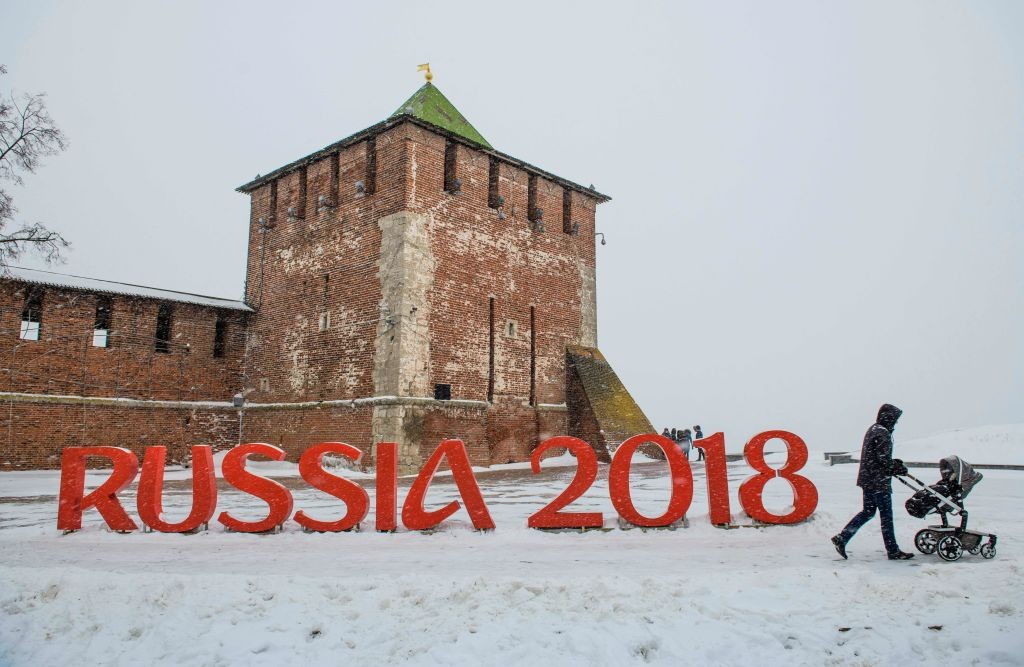 A man pushes a stroler past a FIFA World Cup 2018 emblem placed in front of the Nizhny Novgorod's Kremlin on January 21, 2018. / AFP PHOTO / Mladen ANTONOV (Photo credit should read MLADEN ANTONOV/AFP/Getty Images)