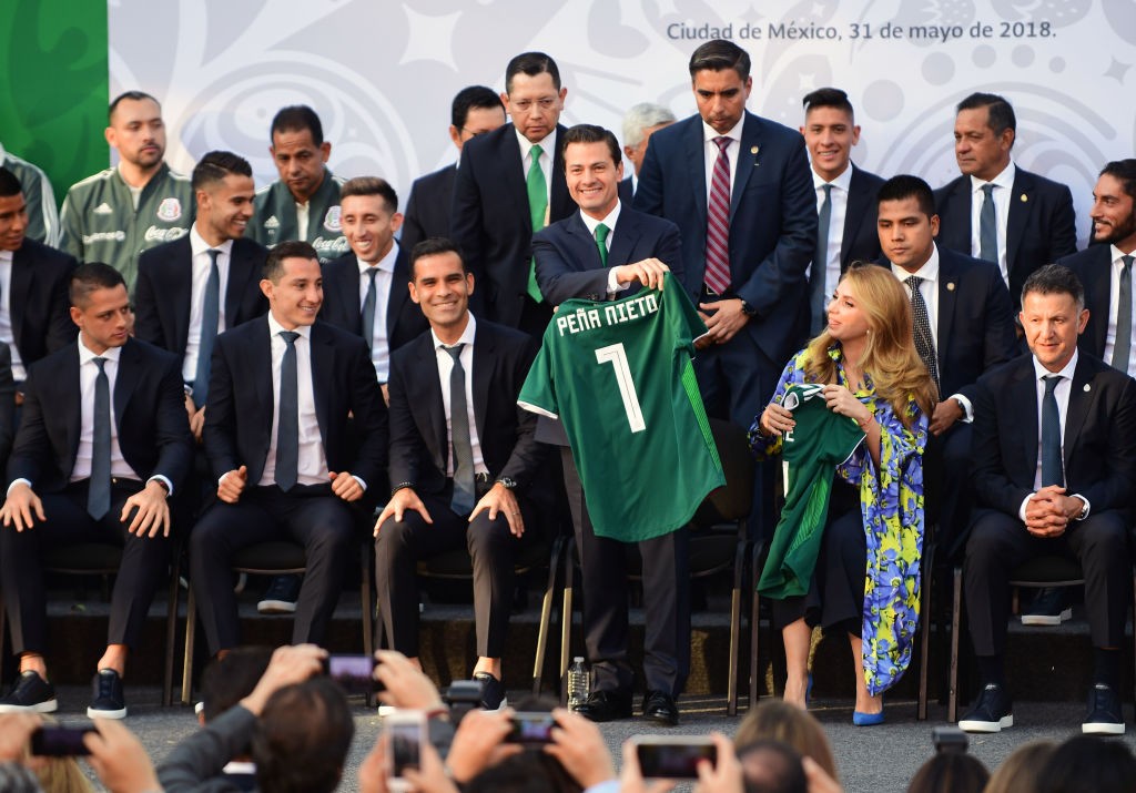Mexican President Enrique Pena Nieto (3-R) holds up the national jersey next to Mexico's national football team player Rafael Marquez (3rd-L), First Lady Angelica Rivera (2-R), the Mexican team head coach Juan Carlos Osorio (R) of Colombia, Mexican players Javier Hernandez (L), and Andres Guardado (2-L), along with other members of the team, during a send-off ceremony at Los Pinos presidential residence in Mexico City on May 31, 2018 ahead of their last friendly match next June 2, against Scotland at the Azteca stadium, before the Mexican team departs to Copenhagen for the the last stage of their preparation ahead of the FIFA World Cup 2018. (Photo by PEDRO PARDO / AFP) (Photo credit should read PEDRO PARDO/AFP/Getty Images)