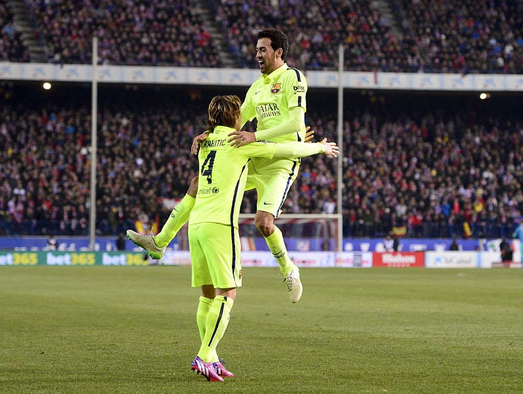 Barcelona's midfielder Sergio Busquets (R) and Barcelona's Croatian midfielder Ivan Rakitic celebrate an own goal by Atletico Madrid's Brazilian defender Joao Miranda during the Spanish Copa del Rey (King's Cup) quarter final second leg football match Club Atletico de Madrid vs FC Barcelona at the Vicente Calderon stadium in Madrid on January 28, 2015. AFP PHOTO/ DANI POZO (Photo credit should read DANI POZO/AFP/Getty Images)