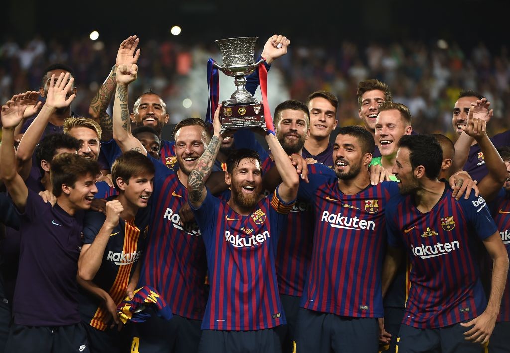 Barcelona's Argentinian forward Lionel Messi (C) carries the cup as they celebrate at the end of the Spanish Super Cup final between Sevilla FC and FC Barcelona at Ibn Batouta Stadium in the Moroccan city of Tangiers on August 12, 2018. - Barcelona defeated Sevilla 2-1 to win the Spanish Super Cup. (Photo by FADEL SENNA / AFP) (Photo credit should read FADEL SENNA/AFP/Getty Images)