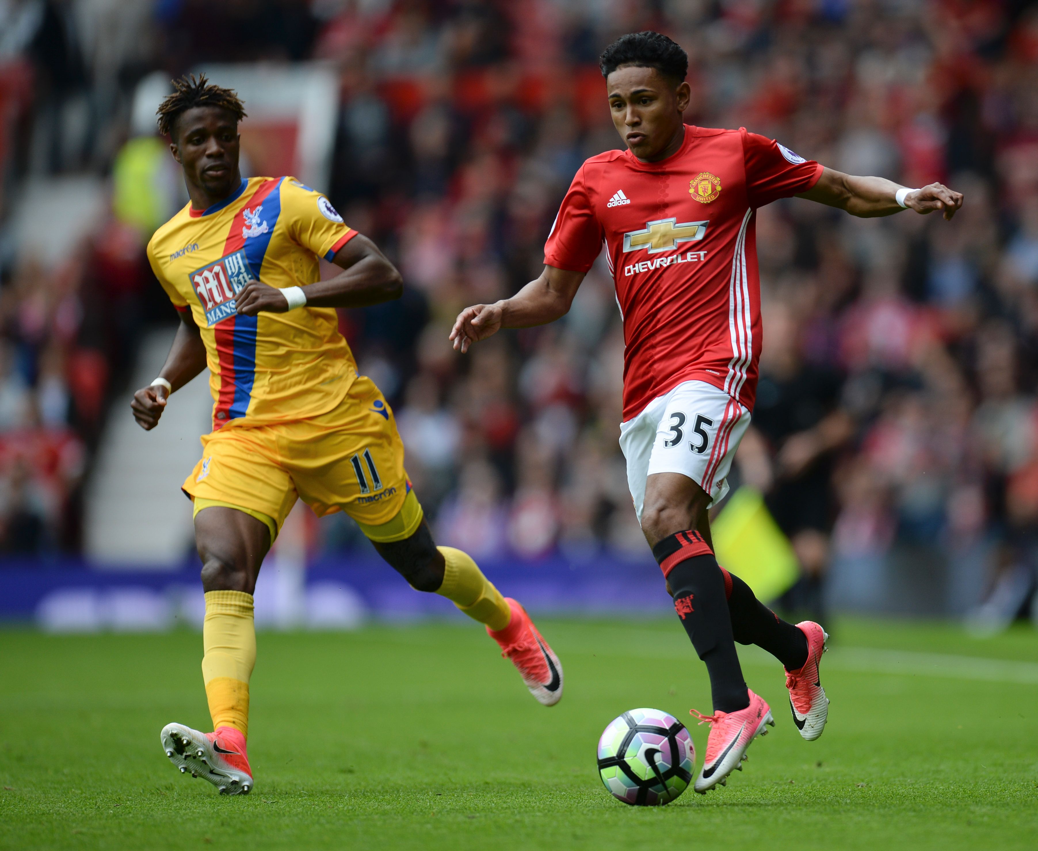 Manchester United's English defender Demetri Mitchell (R) battles with Crystal Palace's Ivorian striker Wilfried Zaha (L) during the English Premier League football match between Manchester United and Cyrstal Palace at Old Trafford in Manchester, north west England, on May 21, 2017. / AFP PHOTO / Oli SCARFF / RESTRICTED TO EDITORIAL USE. No use with unauthorized audio, video, data, fixture lists, club/league logos or 'live' services. Online in-match use limited to 75 images, no video emulation. No use in betting, games or single club/league/player publications.  /         (Photo credit should read OLI SCARFF/AFP/Getty Images)
