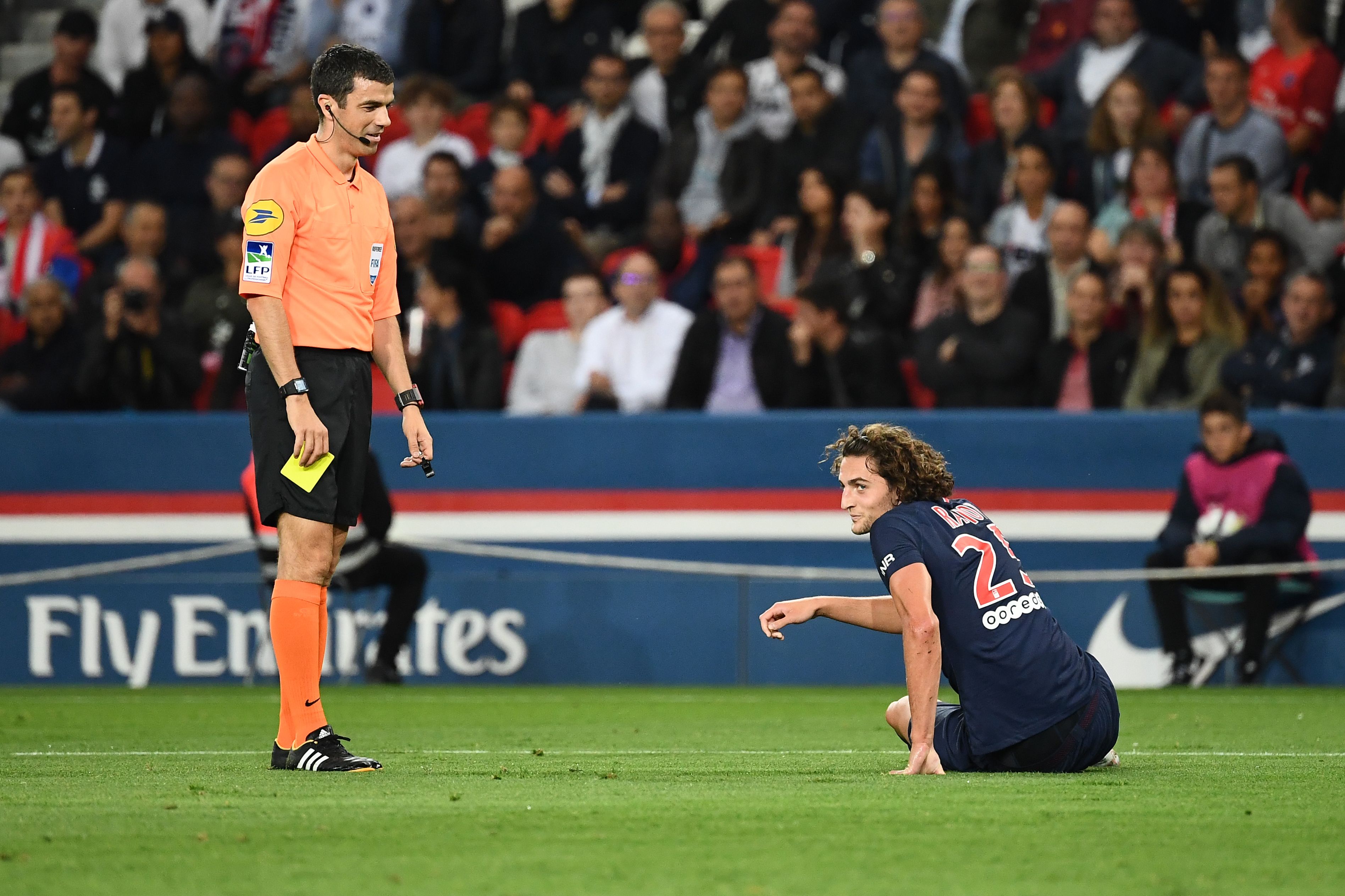Paris Saint-Germain's French midfielder Adrien Rabiot (R) receives a yellow card from French referee Frank Schneider during the French L1 football match between Paris Saint-Germain (PSG) and Saint-Etienne (ASSE) at the Parc des Princes stadium in Paris on September 14, 2018. (Photo by Anne-Christine POUJOULAT / AFP)        (Photo credit should read ANNE-CHRISTINE POUJOULAT/AFP/Getty Images)