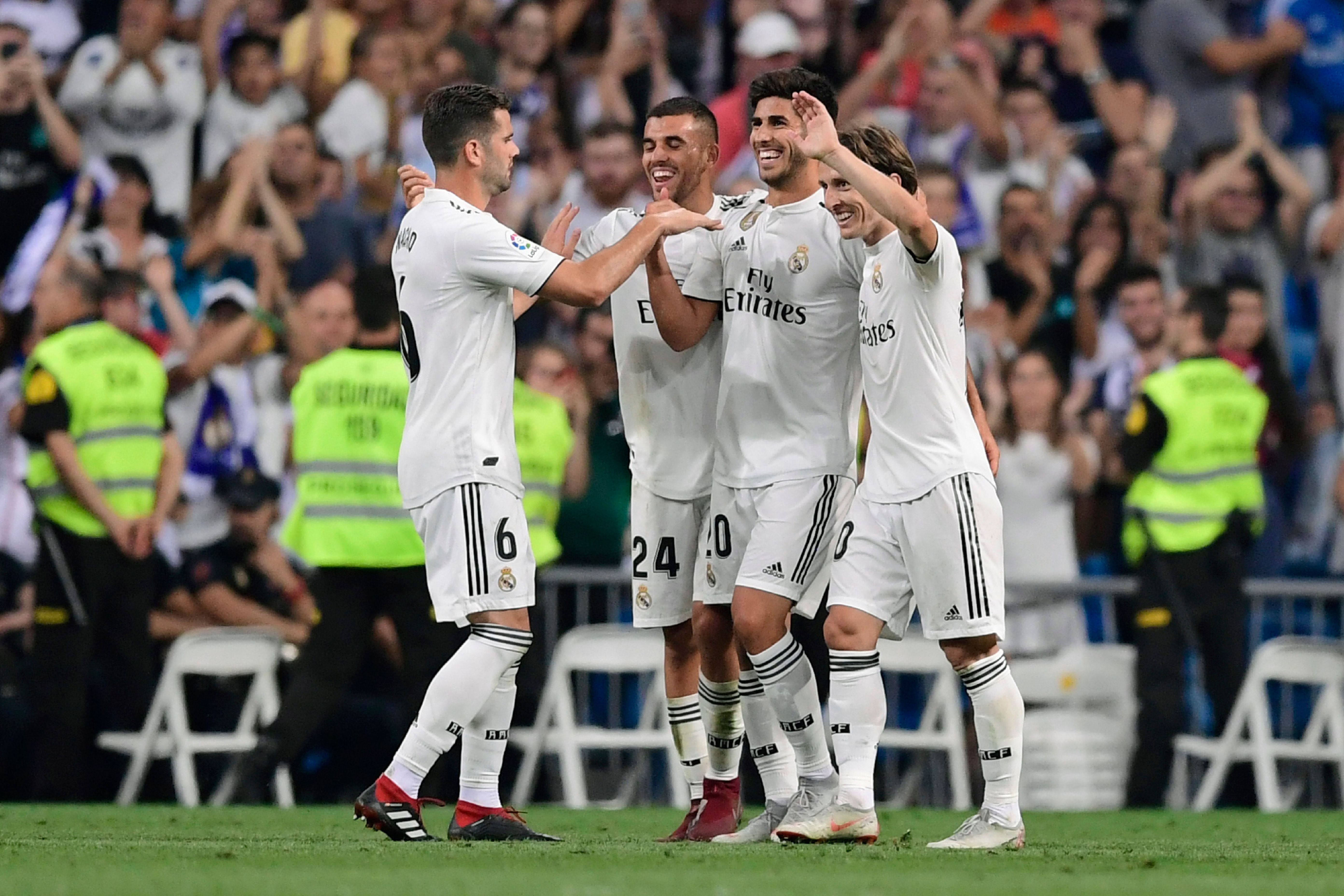Real Madrid's Spanish midfielder Marco Asensio (C) celebrates with teammtes after scoring during the Spanish league football match between Real Madrid CF and RCD Espanyol at the Santiago Bernabeu stadium in Madrid on September 22, 2018. (Photo by JAVIER SORIANO / AFP)        (Photo credit should read JAVIER SORIANO/AFP/Getty Images)
