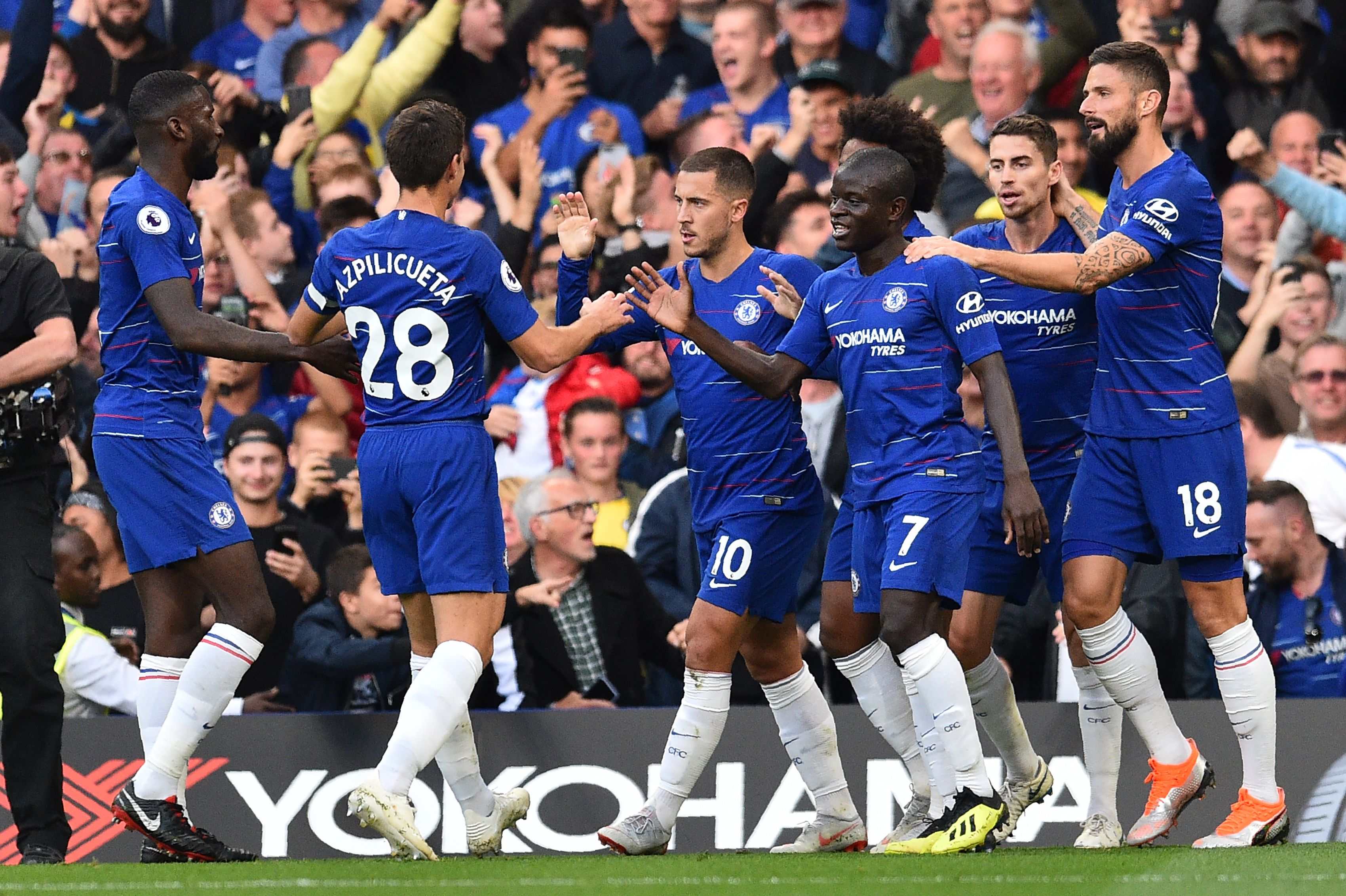 Chelsea's Belgian midfielder Eden Hazard (C) celeb rates with teammates after scoring the team's first goal during the English Premier League football match between Chelsea and Liverpool at Stamford Bridge in London on September 29, 2018. (Photo by Glyn KIRK / AFP) / RESTRICTED TO EDITORIAL USE. No use with unauthorized audio, video, data, fixture lists, club/league logos or 'live' services. Online in-match use limited to 120 images. An additional 40 images may be used in extra time. No video emulation. Social media in-match use limited to 120 images. An additional 40 images may be used in extra time. No use in betting publications, games or single club/league/player publications. /         (Photo credit should read GLYN KIRK/AFP/Getty Images)