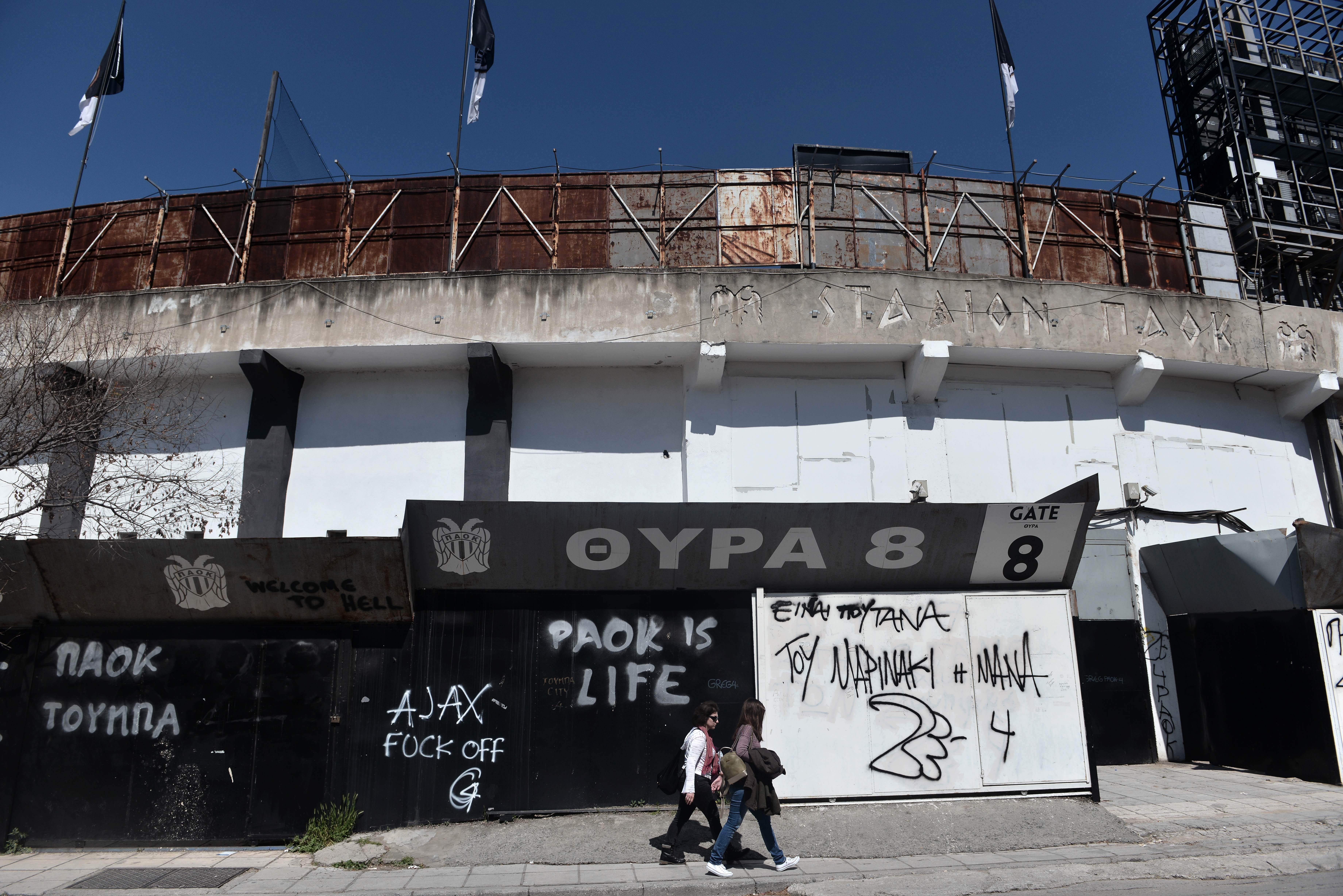 TOPSHOT - People walking next to Toumba stadium, home of PAOK FC, in Thessaloniki on March 29, 2018.
The owner of Greek club PAOK has been banned for three years after storming onto the pitch with a holstered gun on his belt,league organisers said.
PAOK were also docked three points and fined for Ivan Savvidis'actions meaning they drop to third place in a tight championship race. / AFP PHOTO / SAKIS MITROLIDIS        (Photo credit should read SAKIS MITROLIDIS/AFP/Getty Images)