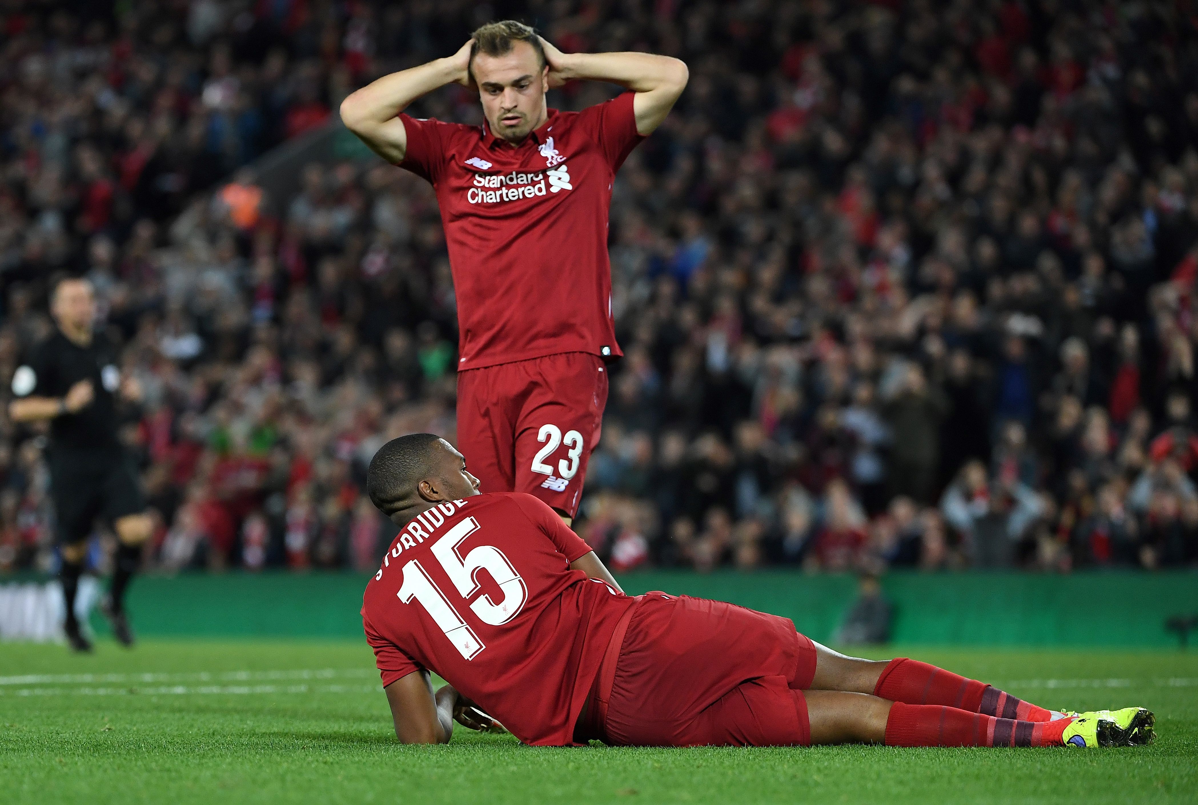 Liverpool's Swiss midfielder Xherdan Shaqiri (C) reacts after Liverpool's English striker Daniel Sturridge missed an open goal during the English League Cup third round football match between Liverpool and Chelsea at Anfield in Liverpool, north west England on September 26, 2018. (Photo by Paul ELLIS / AFP) / RESTRICTED TO EDITORIAL USE. No use with unauthorized audio, video, data, fixture lists, club/league logos or 'live' services. Online in-match use limited to 120 images. An additional 40 images may be used in extra time. No video emulation. Social media in-match use limited to 120 images. An additional 40 images may be used in extra time. No use in betting publications, games or single club/league/player publications. /         (Photo credit should read PAUL ELLIS/AFP/Getty Images)