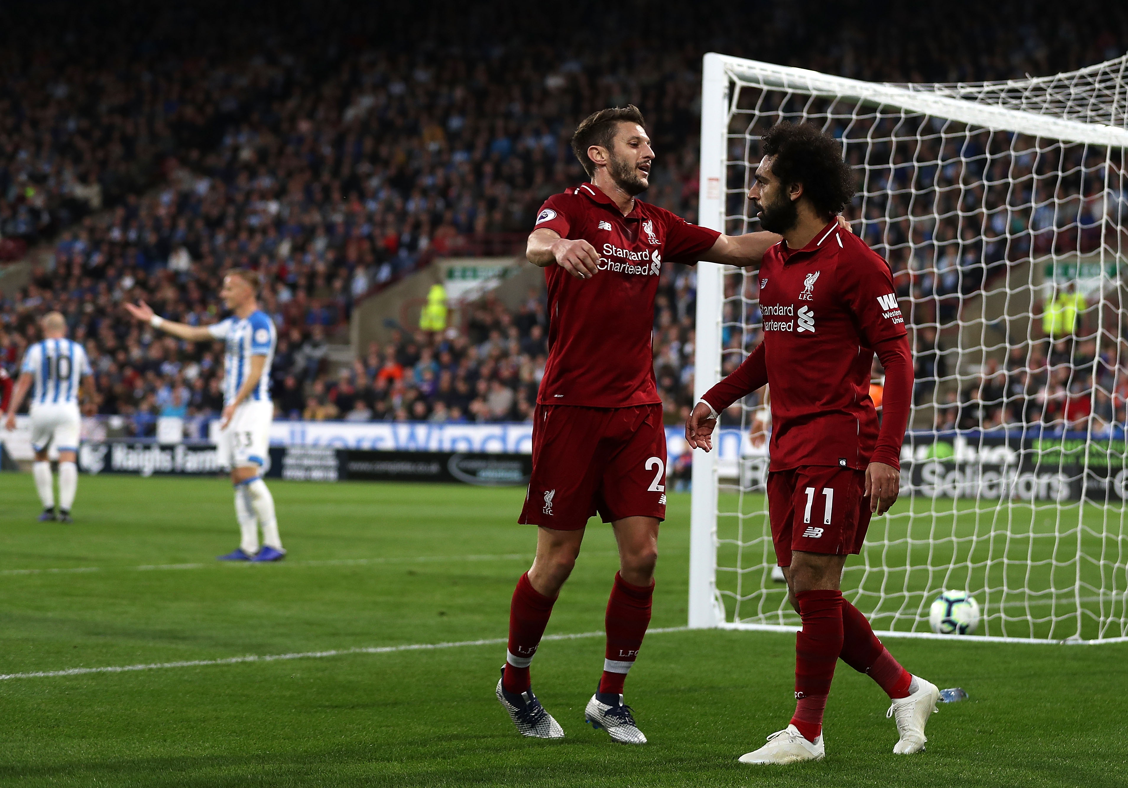 HUDDERSFIELD, ENGLAND - OCTOBER 20: Mohamed Salah of Liverpool(R) celebrates with Adam Lallana of Liverpool after scoring his sides first goal during the Premier League match between Huddersfield Town and Liverpool FC at John Smith's Stadium on October 20, 2018 in Huddersfield, United Kingdom. (Photo by Mark Robinson/Getty Images)