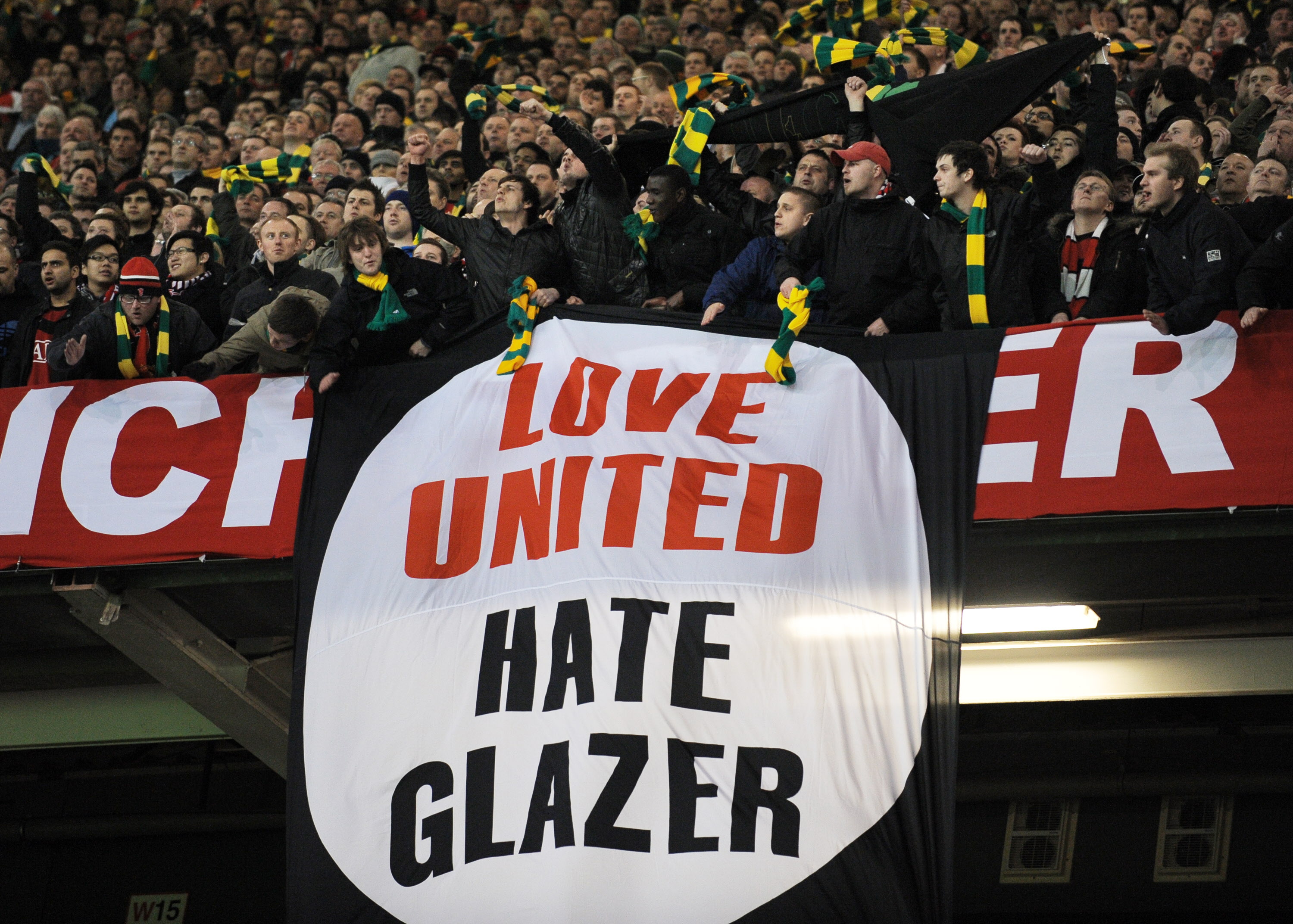 Manchester United supporters hold an anti-Glazer family banner during their UEFA Champions League round of 16, second leg football match against AC Milan at Old Trafford in Manchester, north-west England, on March 10, 2010. Manchester won 4-0.  AFP PHOTO/ANDREW YATES (Photo credit should read ANDREW YATES/AFP/Getty Images)