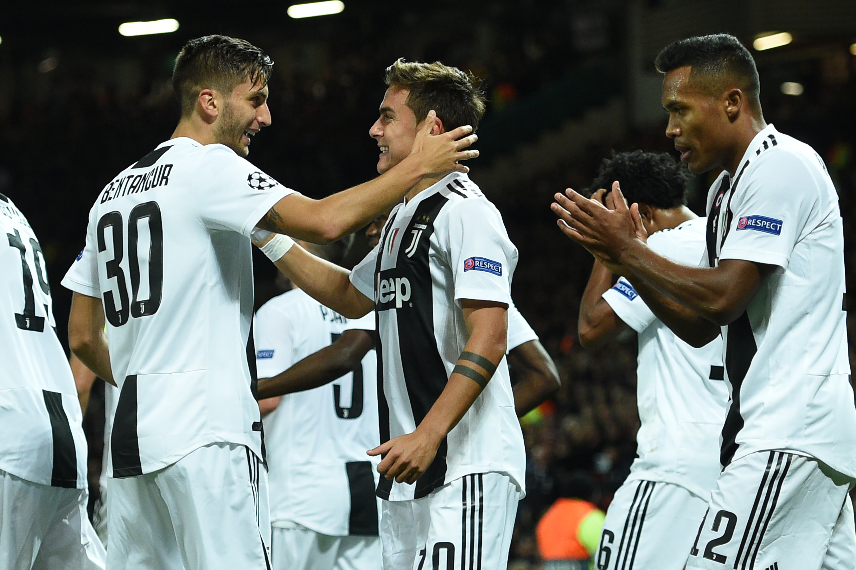 Juventus' Argentinian striker Paulo Dybala (C) celebrates with Juventus' Uruguayan midfielder Rodrigo Bentancur (L) after scoring the opening goal of the Champions League group H football match between Manchester United and Juventus at Old Trafford in Manchester, north west England, on October 23, 2018. (Photo by Oli SCARFF / AFP)        (Photo credit should read OLI SCARFF/AFP/Getty Images)