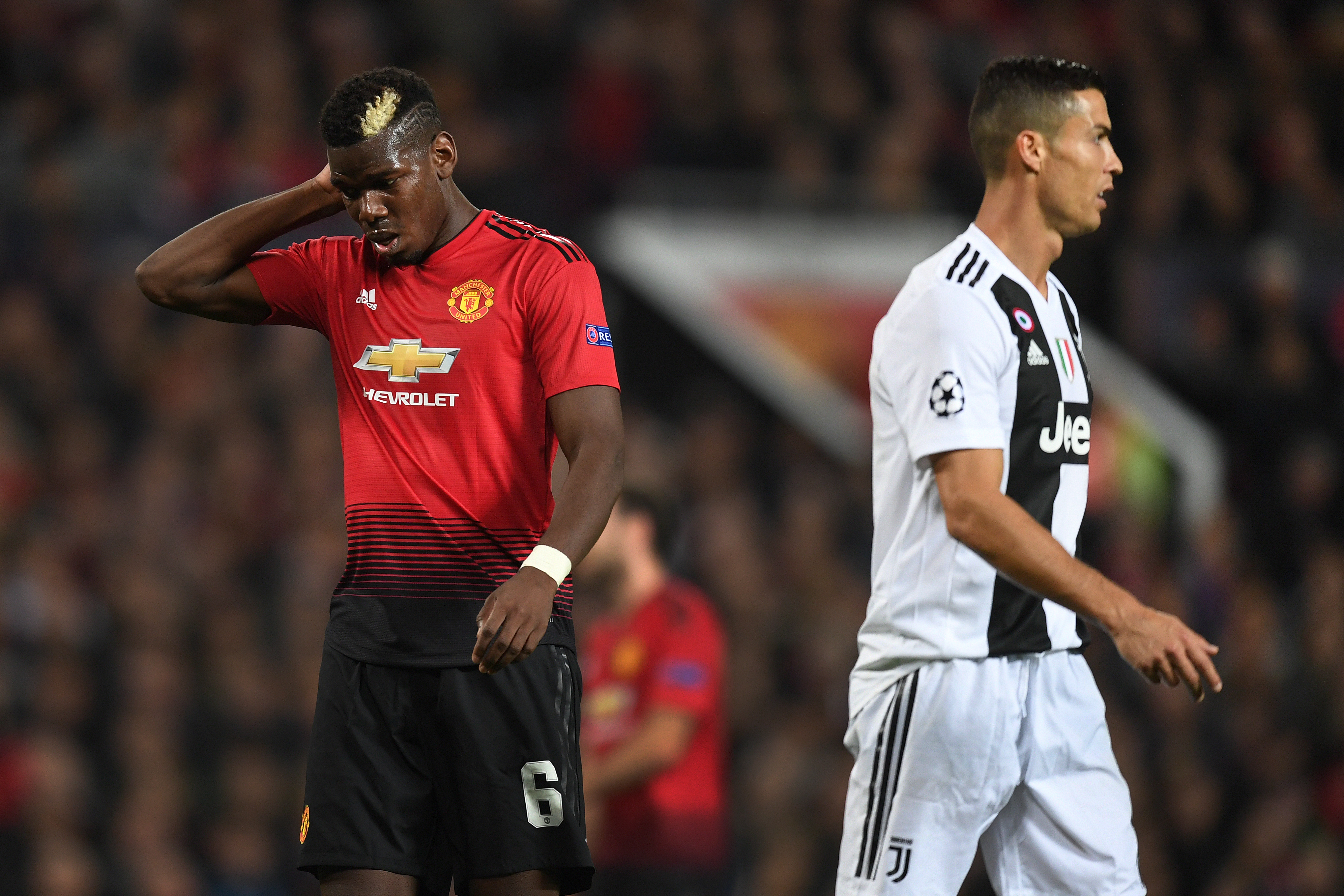 MANCHESTER, ENGLAND - OCTOBER 23:  Paul Pogba of Manchester United looks dejected as Cristiano Ronaldo of Juventus looks on during the Group H match of the UEFA Champions League between Manchester United and Juventus at Old Trafford on October 23, 2018 in Manchester, United Kingdom.  (Photo by Michael Regan/Getty Images)