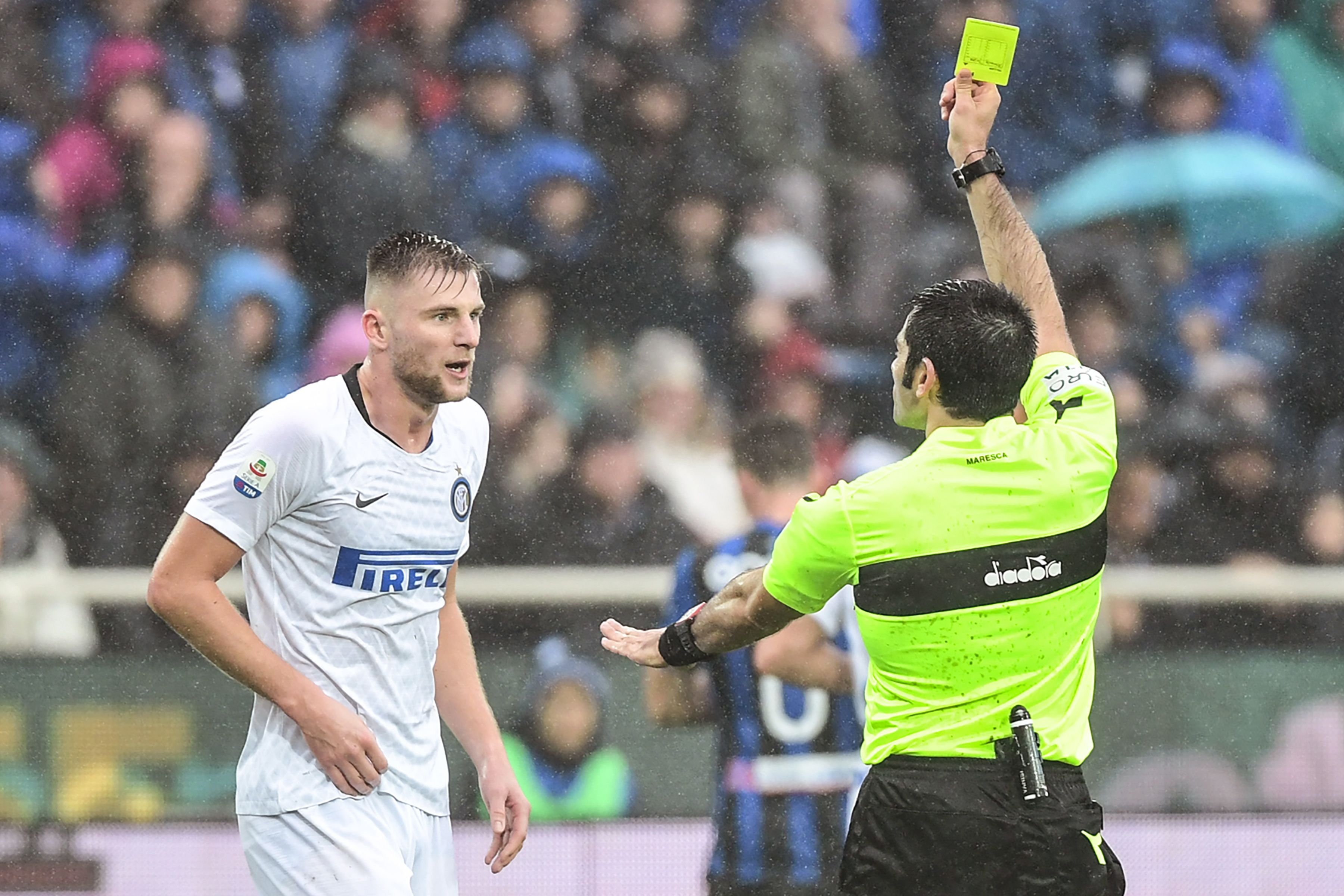 Italian referee Fabio Maresca (R) gives a yellow card to Inter Milan's Slovak defender Milan Skriniar during the Italian Serie A football match Atalanta Bergamo v Inter Milan at the Atleti Azzuri d'Italia stadium on November 11, 2018 in Bergamo. (Photo by Miguel MEDINA / AFP)        (Photo credit should read MIGUEL MEDINA/AFP/Getty Images)