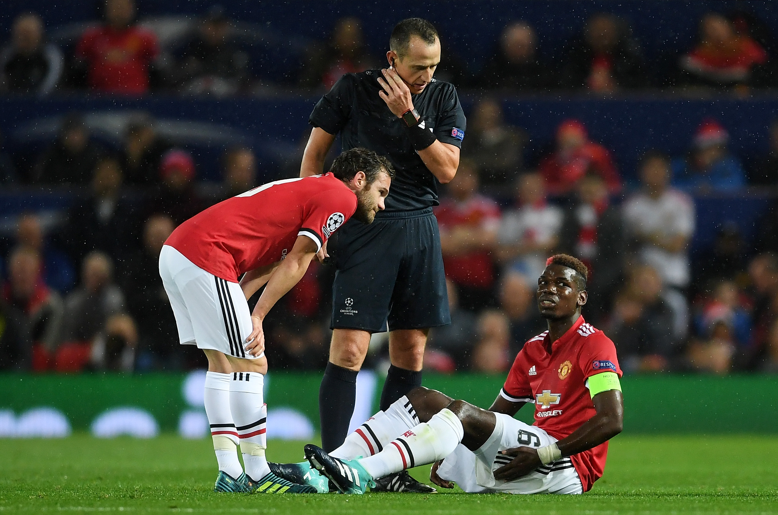 MANCHESTER, ENGLAND - SEPTEMBER 12: Juan Mata of Manchester United checks if Paul Pogba of Manchestr United is okay after he goes down injured during the UEFA Champions League Group A match between Manchester United and FC Basel at Old Trafford on September 12, 2017 in Manchester, United Kingdom.  (Photo by Laurence Griffiths/Getty Images)