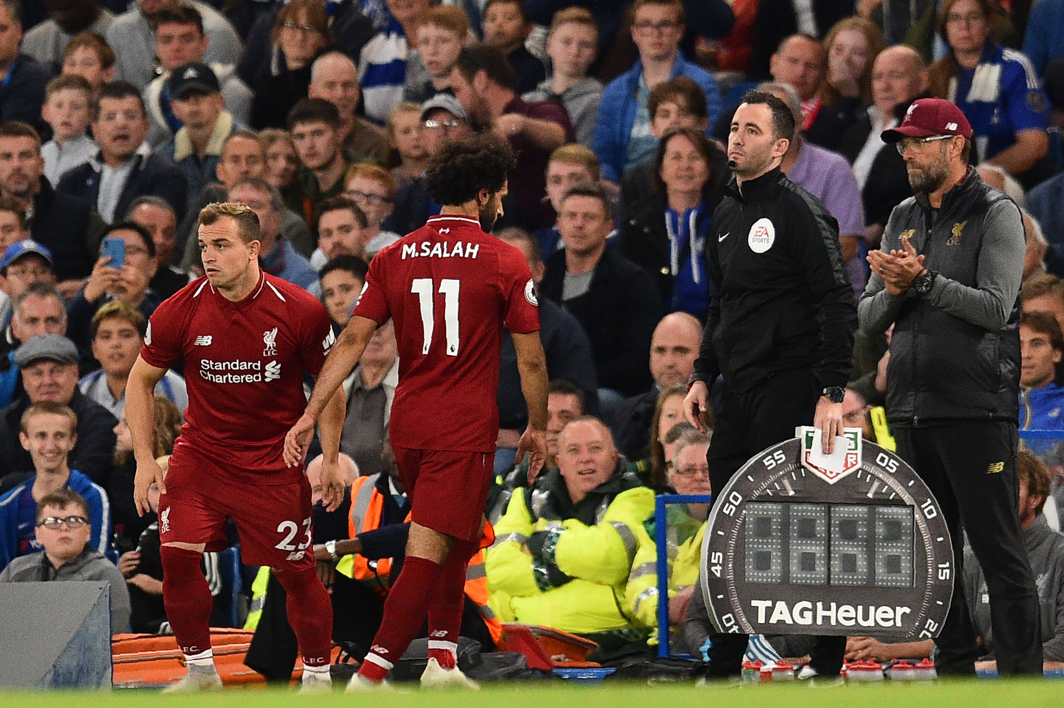 Liverpool's Swiss midfielder Xherdan Shaqiri (L) substitutes Liverpool's Egyptian midfielder Mohamed Salah (2L) as Liverpool's German manager Jurgen Klopp (R) looks on during the English Premier League football match between Chelsea and Liverpool at Stamford Bridge in London on September 29, 2018. (Photo by Glyn KIRK / AFP) / RESTRICTED TO EDITORIAL USE. No use with unauthorized audio, video, data, fixture lists, club/league logos or 'live' services. Online in-match use limited to 120 images. An additional 40 images may be used in extra time. No video emulation. Social media in-match use limited to 120 images. An additional 40 images may be used in extra time. No use in betting publications, games or single club/league/player publications. /         (Photo credit should read GLYN KIRK/AFP/Getty Images)