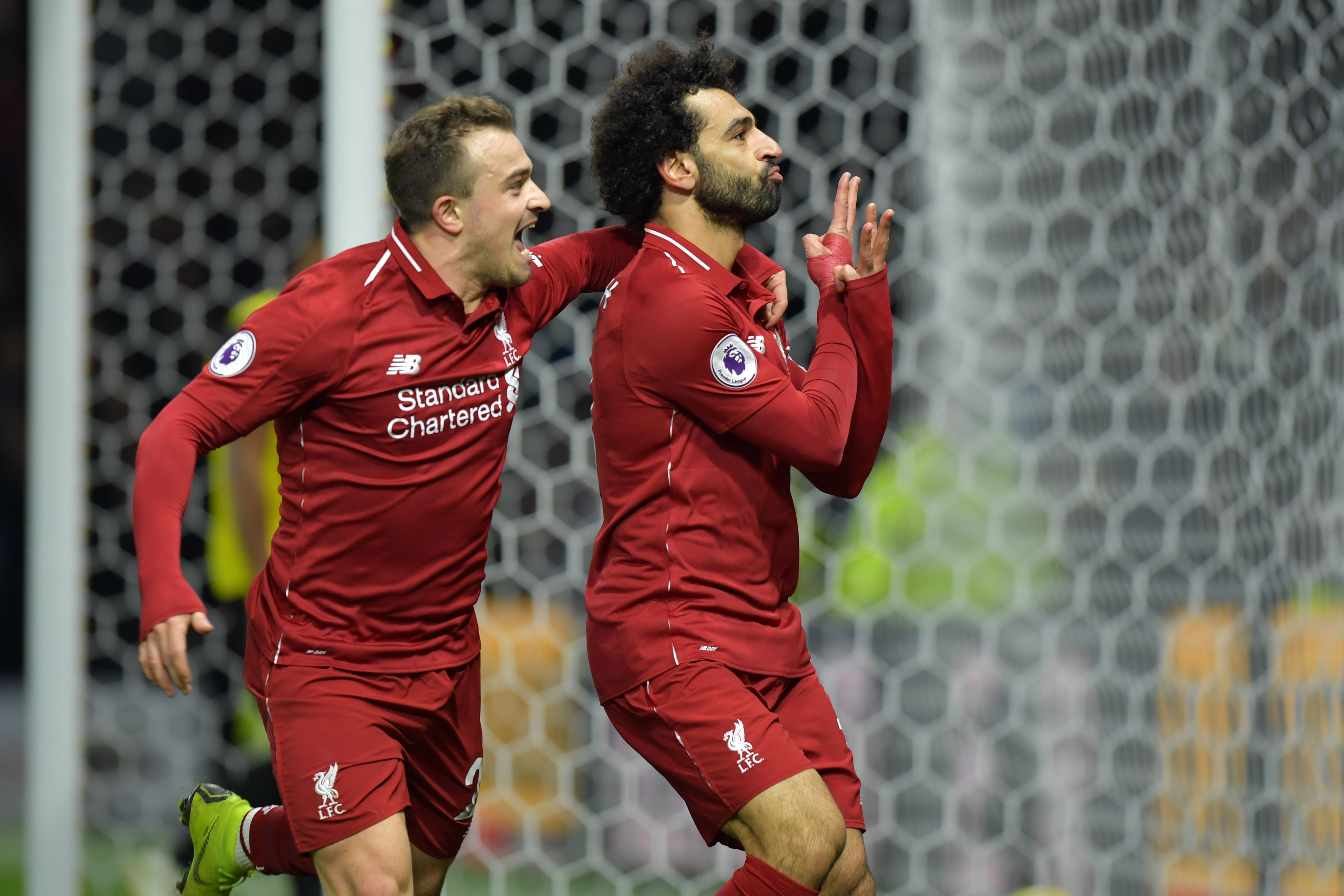Liverpool's Egyptian midfielder Mohamed Salah (R) celebrates with Liverpool's Swiss midfielder Xherdan Shaqiri after scoring the opening goal of the English Premier League football match between Watford and Liverpool at Vicarage Road Stadium in Watford, north of London on November 24, 2018. (Photo by OLLY GREENWOOD / AFP) / RESTRICTED TO EDITORIAL USE. No use with unauthorized audio, video, data, fixture lists, club/league logos or 'live' services. Online in-match use limited to 120 images. An additional 40 images may be used in extra time. No video emulation. Social media in-match use limited to 120 images. An additional 40 images may be used in extra time. No use in betting publications, games or single club/league/player publications. /         (Photo credit should read OLLY GREENWOOD/AFP/Getty Images)