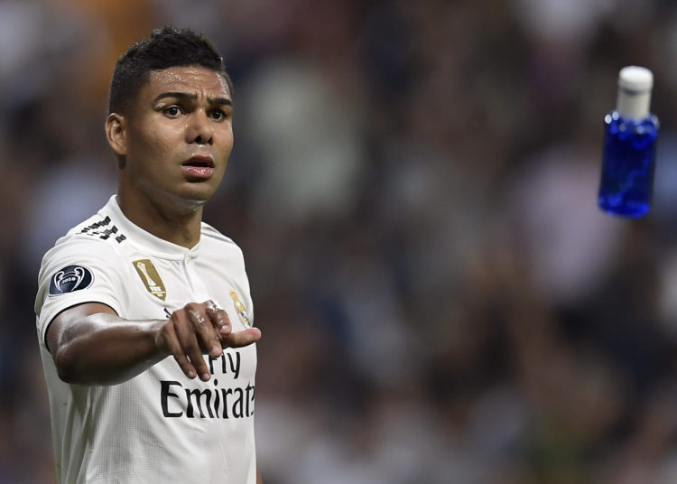 Real Madrid's Brazilian midfielder Casemiro throws a bottle of water to a teammates during the UEFA Champions League group G football match between Real Madrid CF and AS Roma at the Santiago Bernabeu stadium in Madrid on September 19, 2018. (Photo by OSCAR DEL POZO / AFP)        (Photo credit should read OSCAR DEL POZO/AFP/Getty Images)