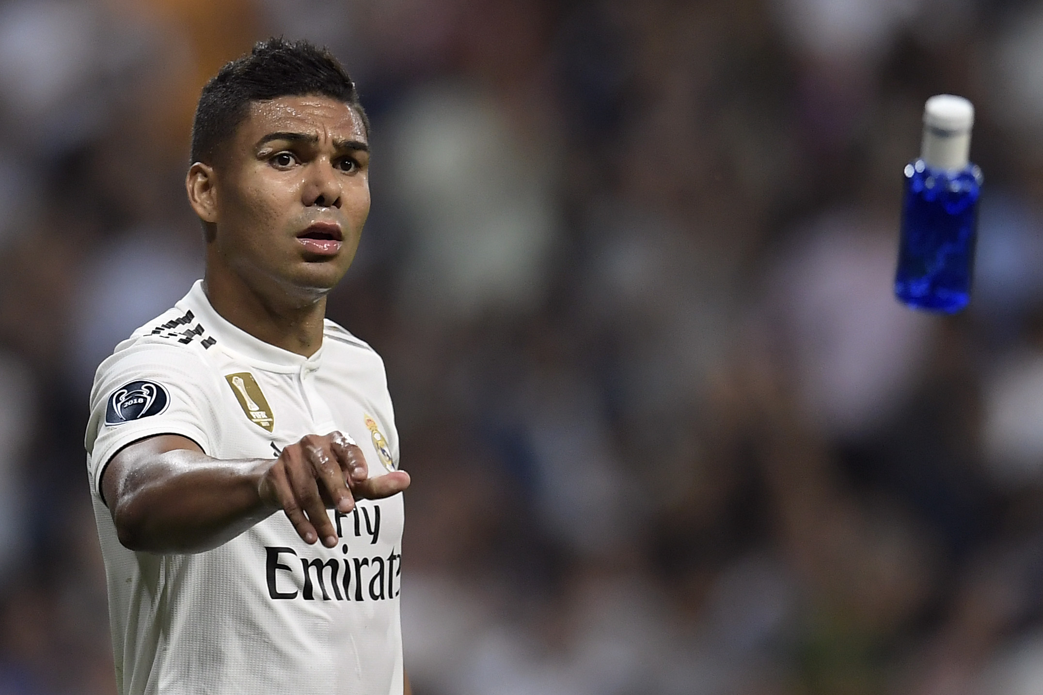 Real Madrid's Brazilian midfielder Casemiro throws a bottle of water to a teammates during the UEFA Champions League group G football match between Real Madrid CF and AS Roma at the Santiago Bernabeu stadium in Madrid on September 19, 2018. (Photo by OSCAR DEL POZO / AFP)        (Photo credit should read OSCAR DEL POZO/AFP/Getty Images)