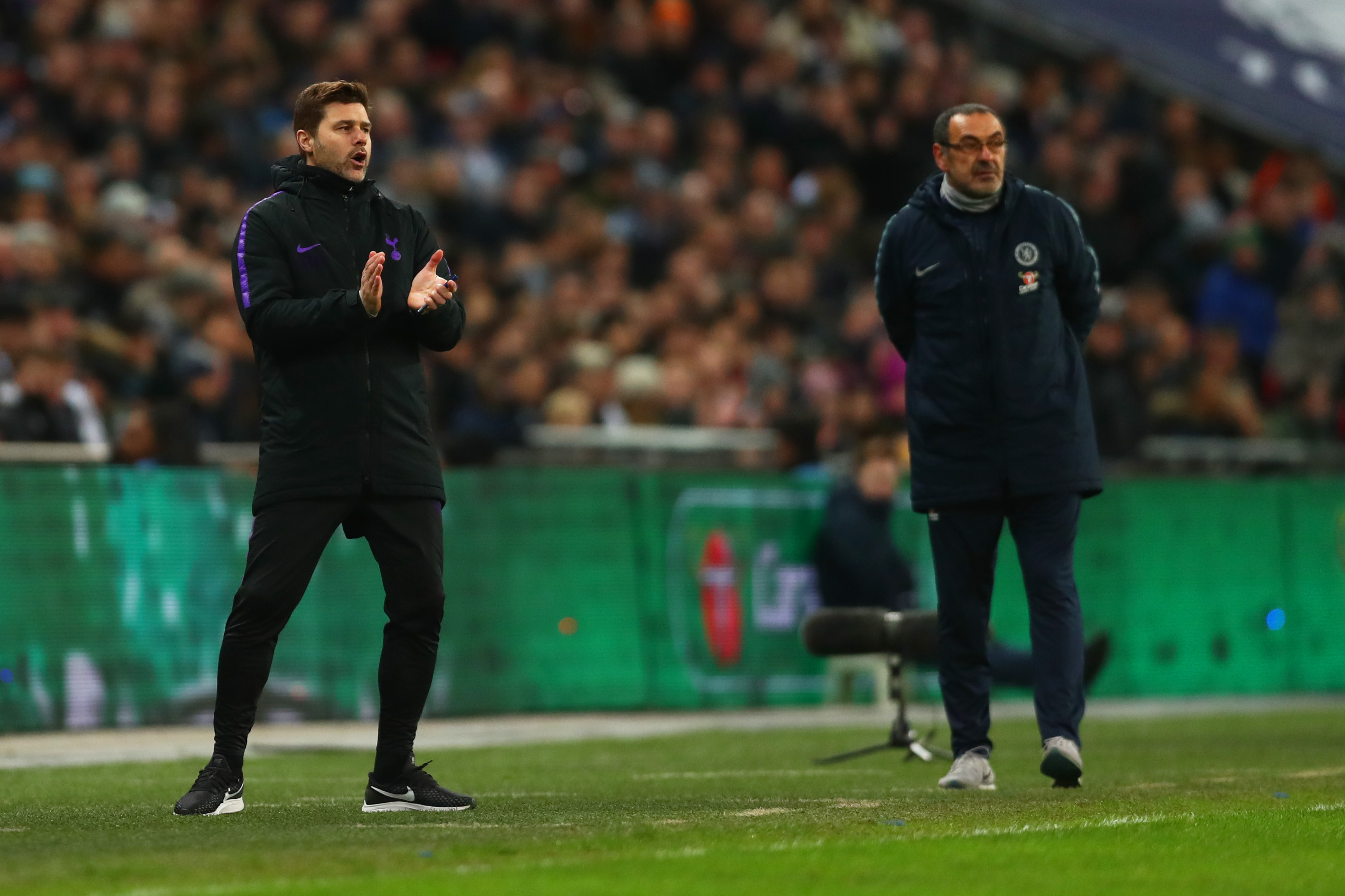 LONDON, ENGLAND - JANUARY 08: Mauricio Pochettino, Manager of Tottenham Hotspur gives his team instructions as Maurizio Sarri, Manager of Chelsea looks on during the Carabao Cup Semi-Final First Leg match between Tottenham Hotspur and Chelsea at Wembley Stadium on January 8, 2019 in London, England.  (Photo by Clive Rose/Getty Images)