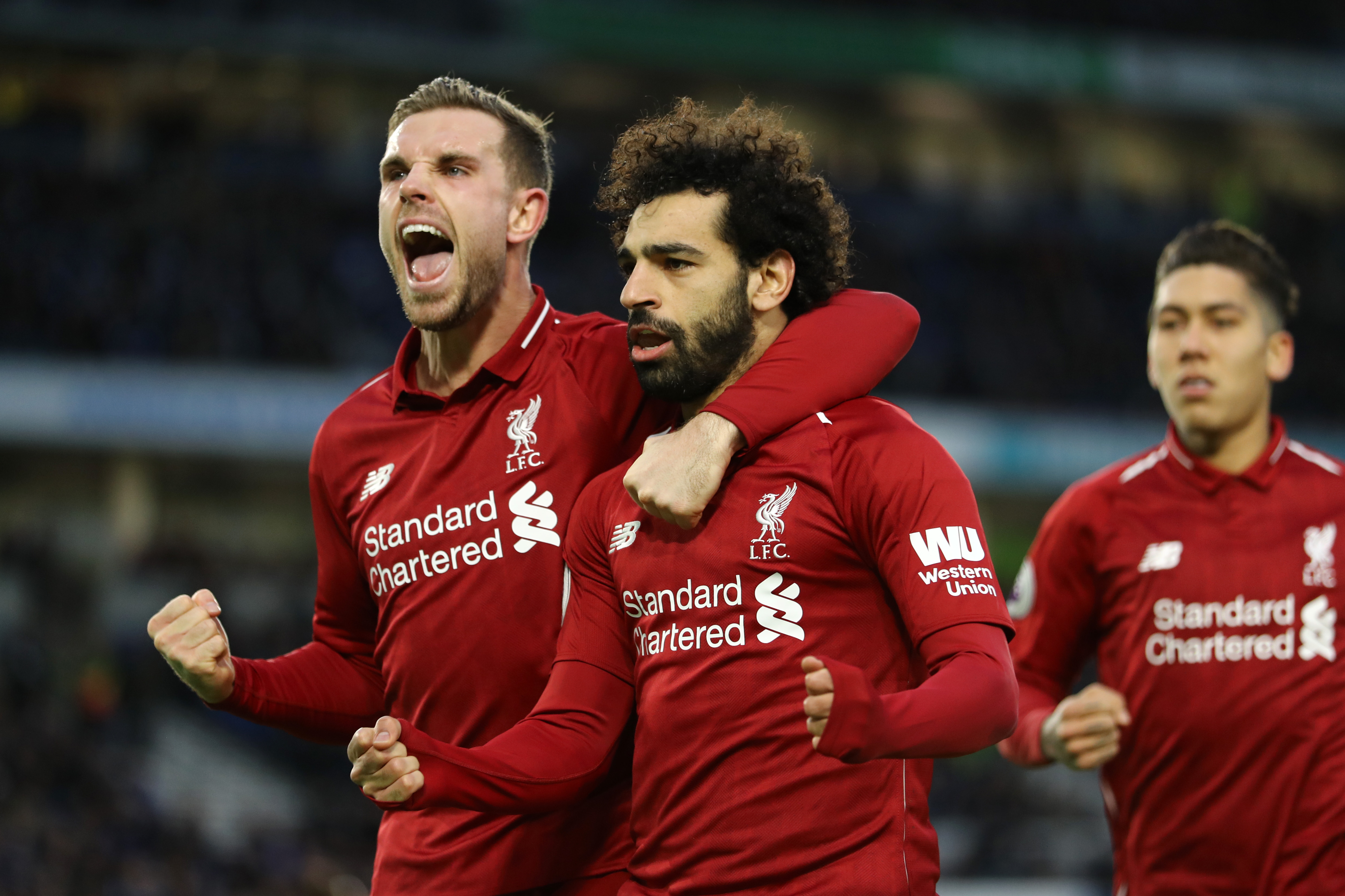 BRIGHTON, ENGLAND - JANUARY 12:  Mohamed Salah of Liverpool celebrates with team mate Jordan Henderason of Liverpool after scoring their first goal from the penalty spot during the Premier League match between Brighton & Hove Albion and Liverpool FC at American Express Community Stadium on January 12, 2019 in Brighton, United Kingdom.  (Photo by Bryn Lennon/Getty Images)