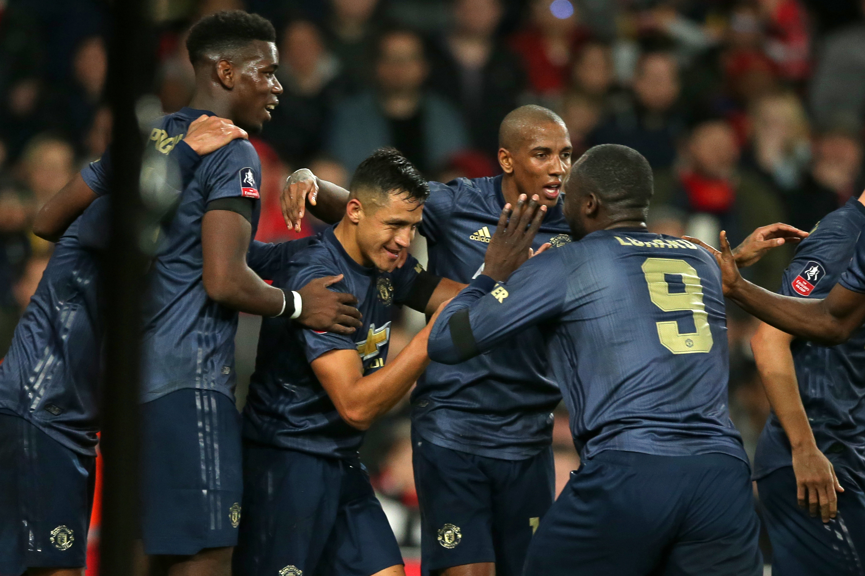 Manchester United's Chilean striker Alexis Sanchez (C) celebrates with teammates after scoring the opening goal of the English FA Cup fourth round football match between Arsenal and Manchester United at the Emirates Stadium in London on January 25, 2019. (Photo by Daniel LEAL-OLIVAS / AFP) / RESTRICTED TO EDITORIAL USE. No use with unauthorized audio, video, data, fixture lists, club/league logos or 'live' services. Online in-match use limited to 120 images. An additional 40 images may be used in extra time. No video emulation. Social media in-match use limited to 120 images. An additional 40 images may be used in extra time. No use in betting publications, games or single club/league/player publications. /         (Photo credit should read DANIEL LEAL-OLIVAS/AFP/Getty Images)