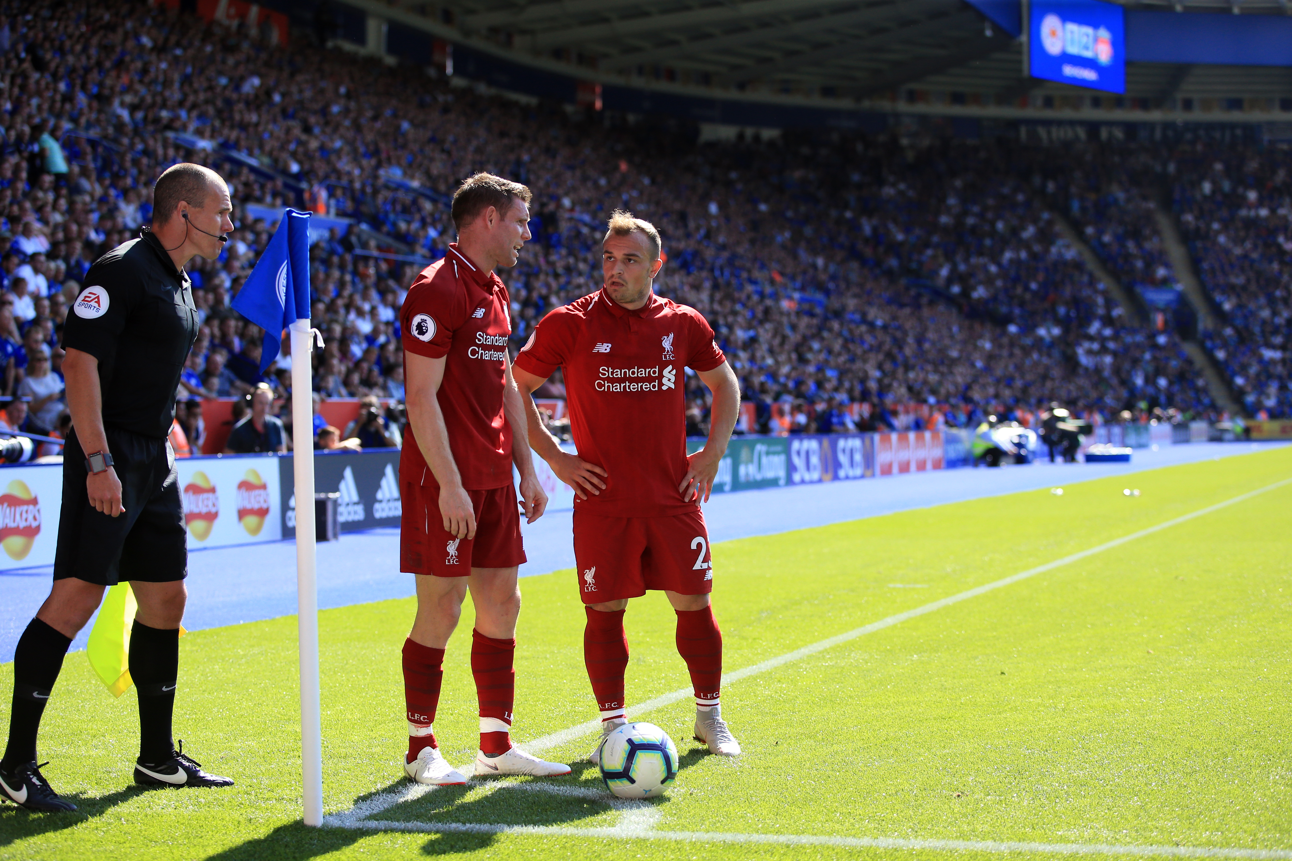LEICESTER, ENGLAND - SEPTEMBER 01:  Xherdan Shaqiri and James Milner of Liverpool in discussion over a corner as the linesman looks on during the Premier League match between Leicester City and Liverpool FC at The King Power Stadium on September 1, 2018 in Leicester, United Kingdom. (Photo by Marc Atkins/Getty Images)