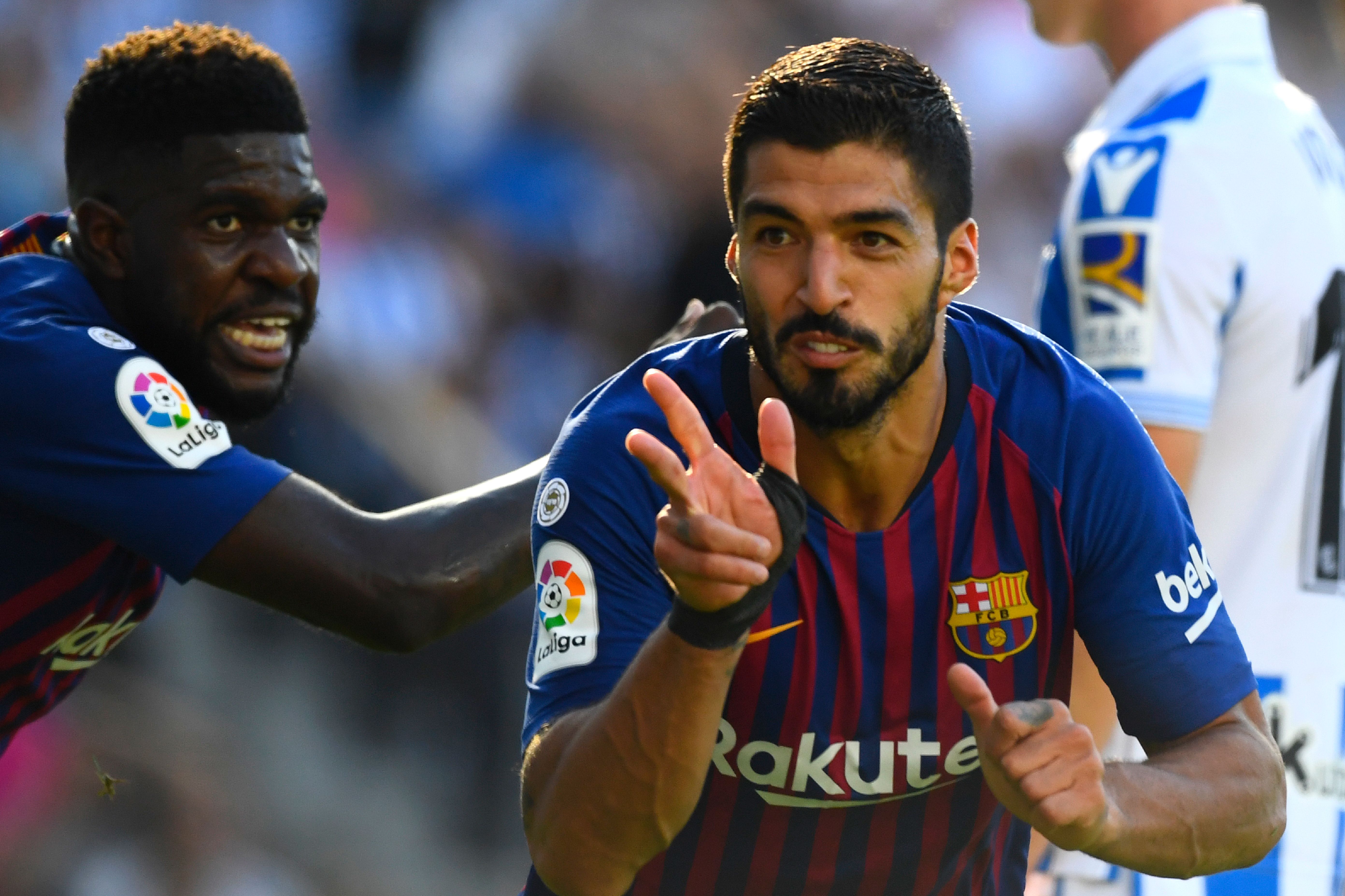 Barcelona's Uruguayan forward Luis Suarez (R) celebrates with Barcelona's French defender Samuel Umtiti after scoring a goal during the Spanish league football match between Real Sociedad and FC Barcelona at the Anoeta stadium in San Sebastian on September 15, 2018. (Photo by GABRIEL BOUYS / AFP)        (Photo credit should read GABRIEL BOUYS/AFP/Getty Images)