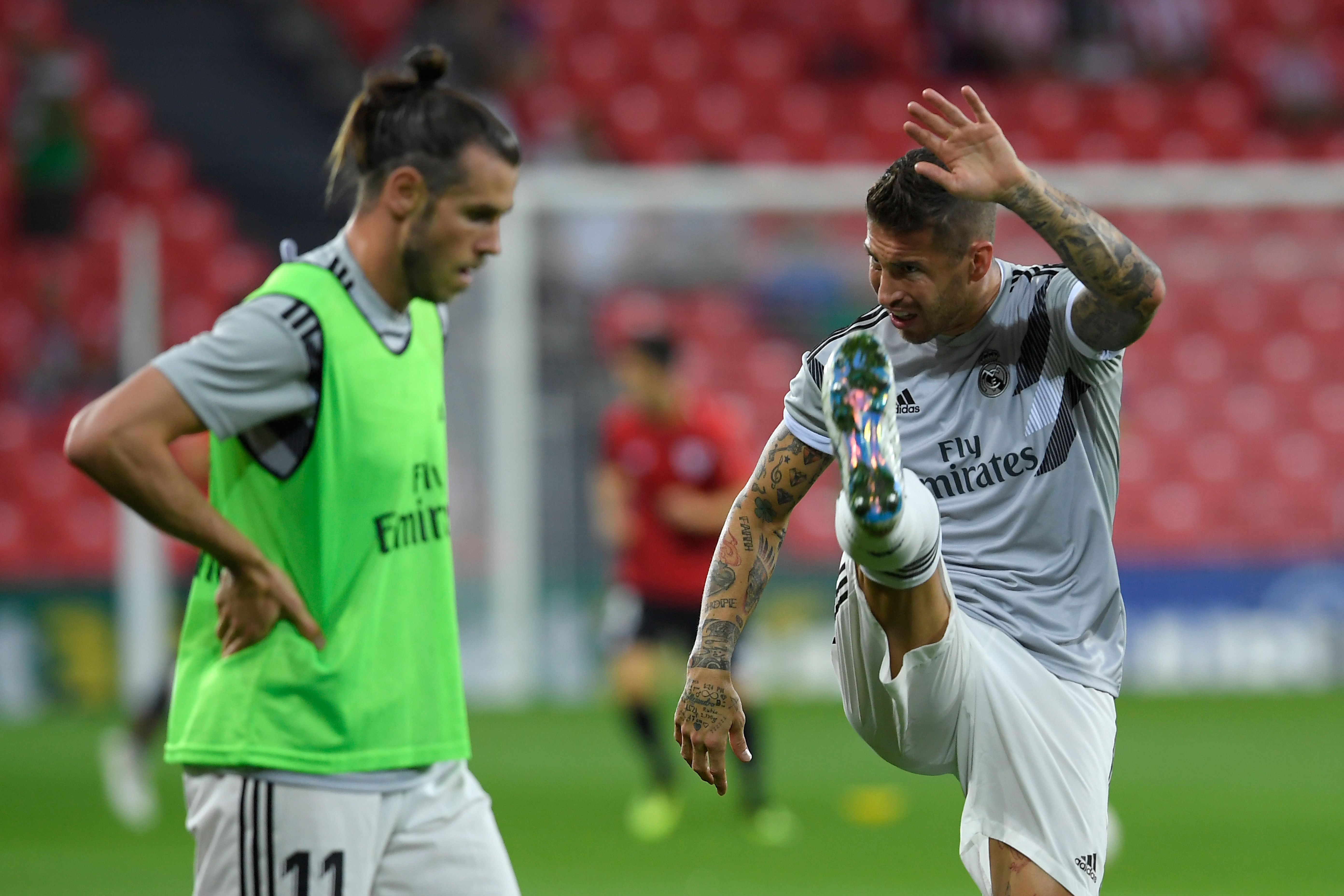 Real Madrid's Welsh forward Gareth Bale (L) and Real Madrid's Spanish defender Sergio Ramos warm up before the Spanish league football match between Athletic Club Bilbao and Real Madrid CF at the San Mames stadium in Bilbao on September 15, 2018. (Photo by LLUIS GENE / AFP)        (Photo credit should read LLUIS GENE/AFP/Getty Images)