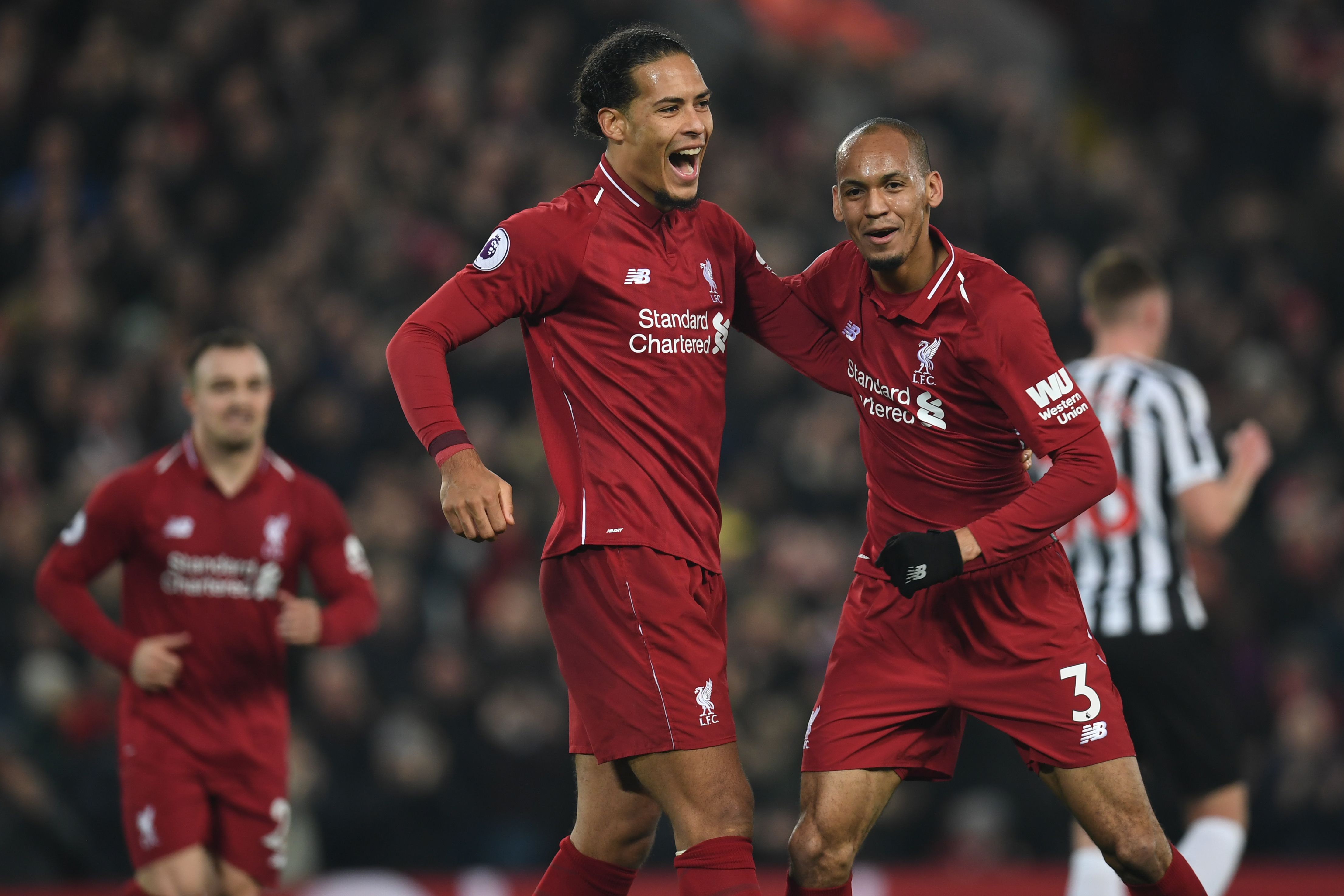 Liverpool's Brazilian midfielder Fabinho (R) celebrates with Liverpool's Dutch defender Virgil van Dijk (C) after scoring their fourth goal during the English Premier League football match between Liverpool and Newcastle United at Anfield in Liverpool, north west England on December 26, 2018. - Liverpool won the game 4-0. (Photo by Paul ELLIS / AFP) / RESTRICTED TO EDITORIAL USE. No use with unauthorized audio, video, data, fixture lists, club/league logos or 'live' services. Online in-match use limited to 120 images. An additional 40 images may be used in extra time. No video emulation. Social media in-match use limited to 120 images. An additional 40 images may be used in extra time. No use in betting publications, games or single club/league/player publications. /         (Photo credit should read PAUL ELLIS/AFP/Getty Images)