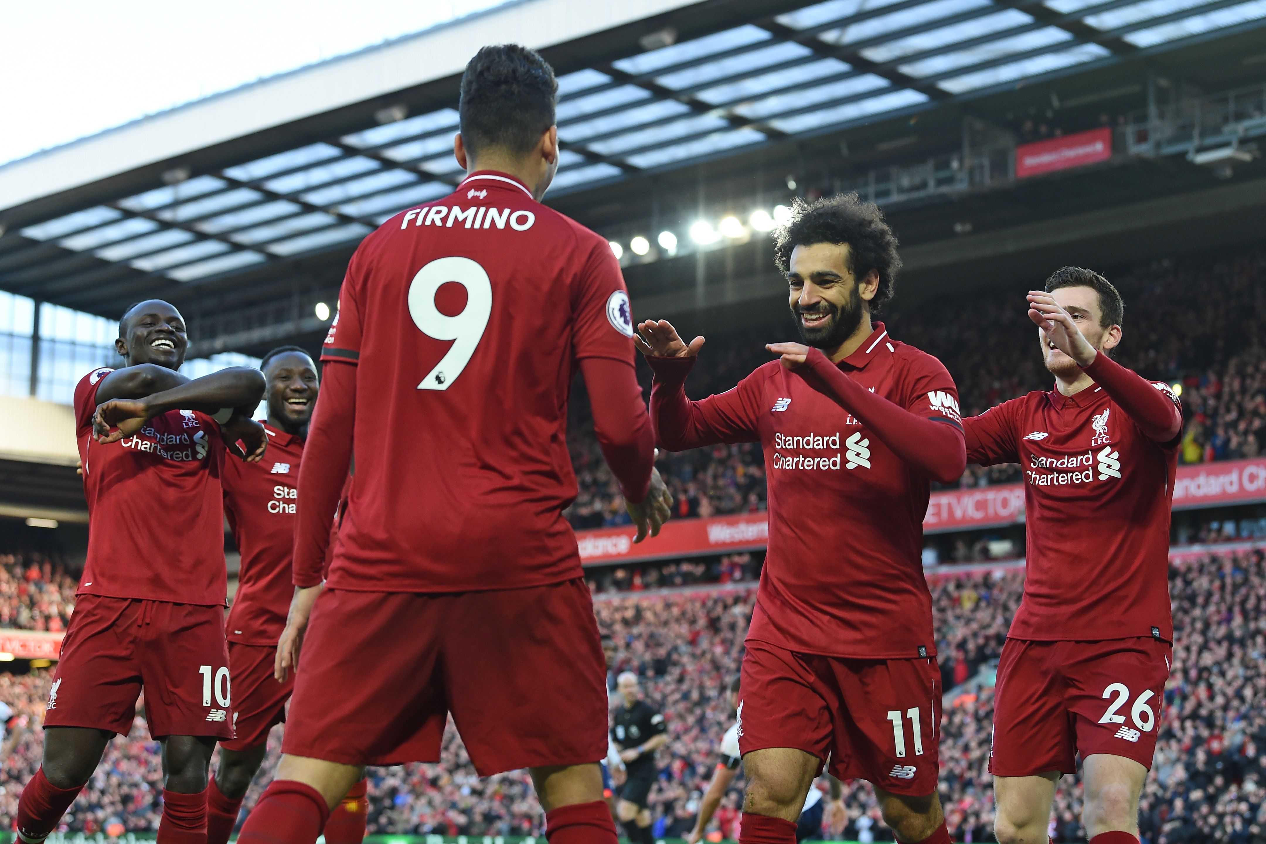 Liverpool's Egyptian midfielder Mohamed Salah (2nd R) celebrates with teammates after scoring their third goal during the English Premier League football match between Liverpool and Bournemouth at Anfield in Liverpool, north west England on February 9, 2019. (Photo by Paul ELLIS / AFP) / RESTRICTED TO EDITORIAL USE. No use with unauthorized audio, video, data, fixture lists, club/league logos or 'live' services. Online in-match use limited to 120 images. An additional 40 images may be used in extra time. No video emulation. Social media in-match use limited to 120 images. An additional 40 images may be used in extra time. No use in betting publications, games or single club/league/player publications. /         (Photo credit should read PAUL ELLIS/AFP/Getty Images)