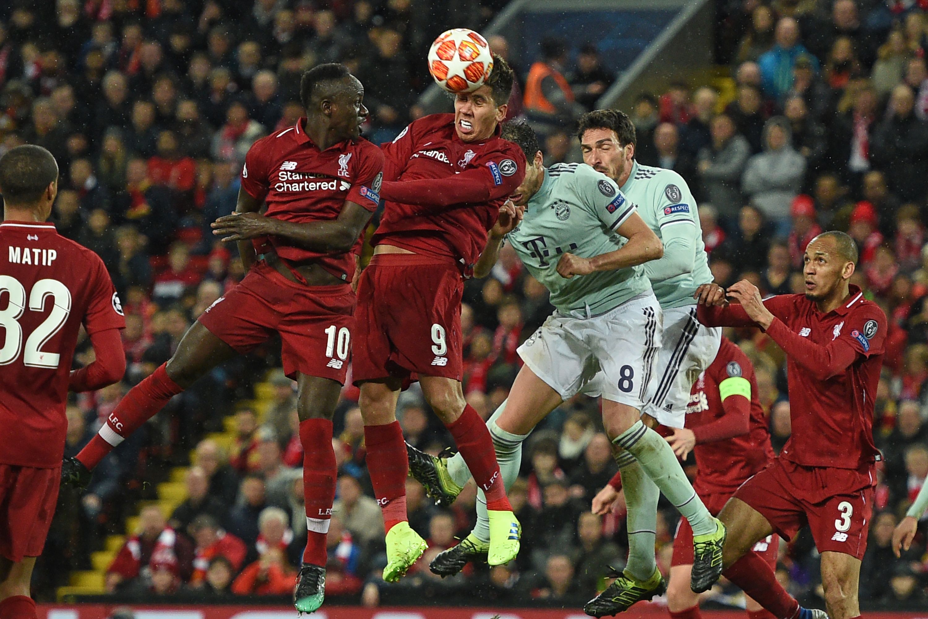 Liverpool's Brazilian midfielder Roberto Firmino (C) wins a defensive header during the UEFA Champions League round of 16, first leg football match between Liverpool and Bayern Munich at Anfield stadium in Liverpool, north-west England on February 19, 2019. (Photo by Oli SCARFF / AFP)        (Photo credit should read OLI SCARFF/AFP/Getty Images)