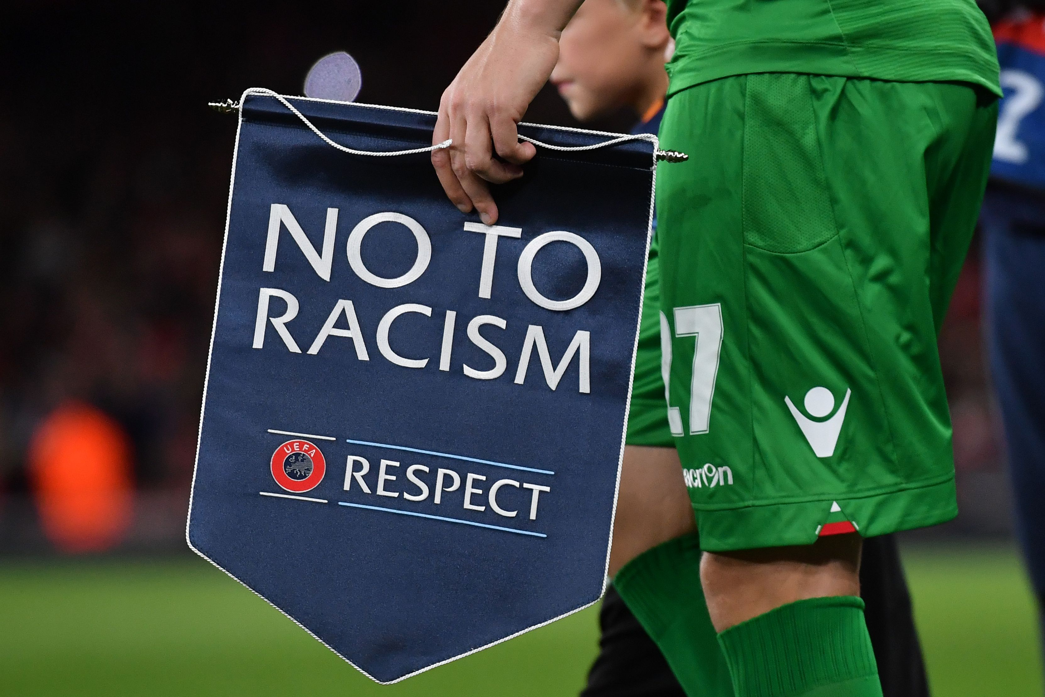 Ludogorets' Romanian defender Cosmin Moti holds an anti-racism banner ahead of the UEFA Champions League Group A football match between Arsenal and Ludogorets Razgrad at The Emirates Stadium in London on October 19, 2016. / AFP / BEN STANSALL        (Photo credit should read BEN STANSALL/AFP/Getty Images)