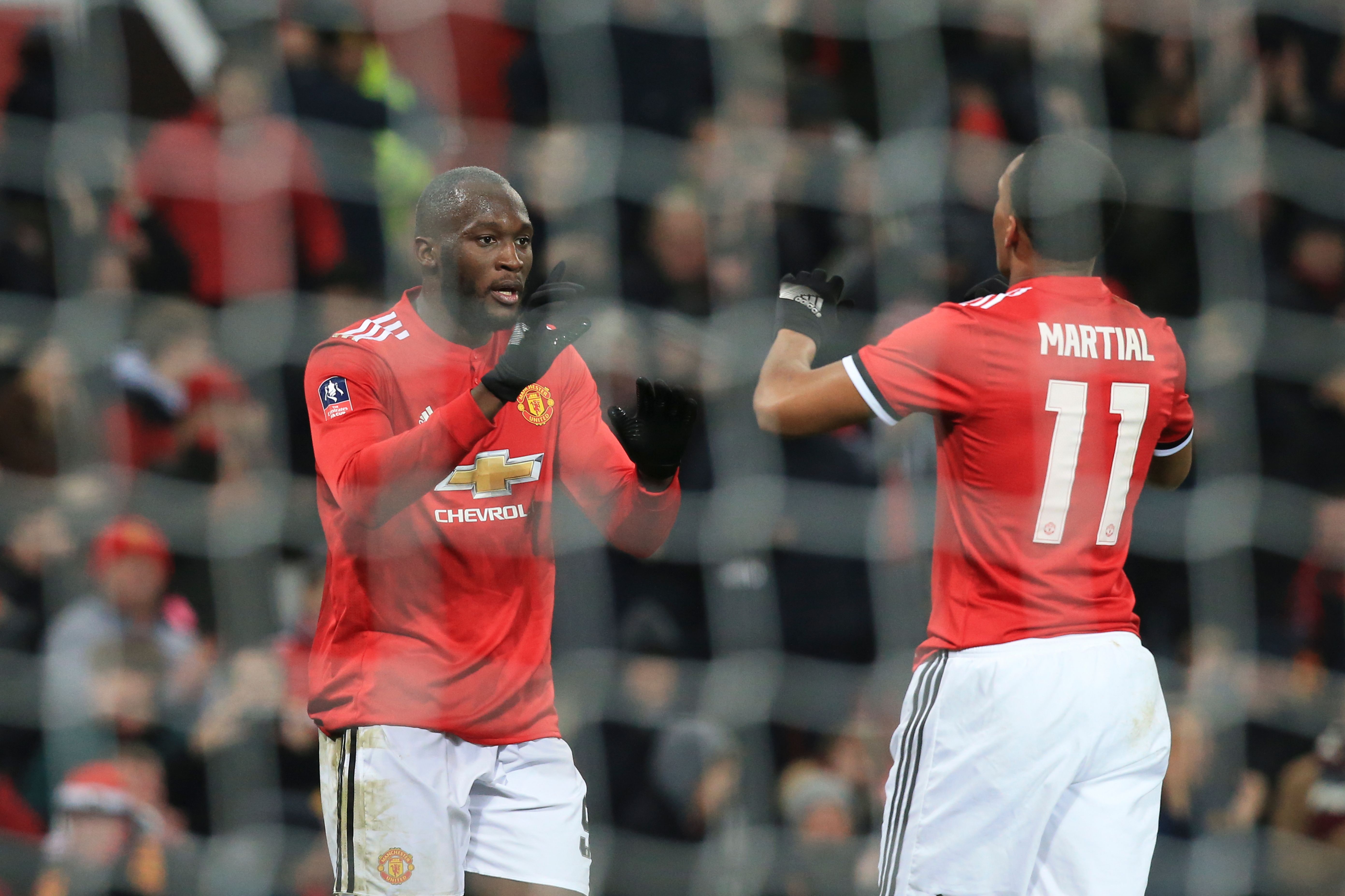 Manchester United's Belgian striker Romelu Lukaku (L) celebrates scoring their second goal with Manchester United's French striker Anthony Martial (R) during the English FA Cup third round football match between Manchester United and Derby County at Old Trafford in Manchester, north west England, on January 5, 2018. / AFP PHOTO / Lindsey PARNABY / RESTRICTED TO EDITORIAL USE. No use with unauthorized audio, video, data, fixture lists, club/league logos or 'live' services. Online in-match use limited to 75 images, no video emulation. No use in betting, games or single club/league/player publications.  /         (Photo credit should read LINDSEY PARNABY/AFP/Getty Images)