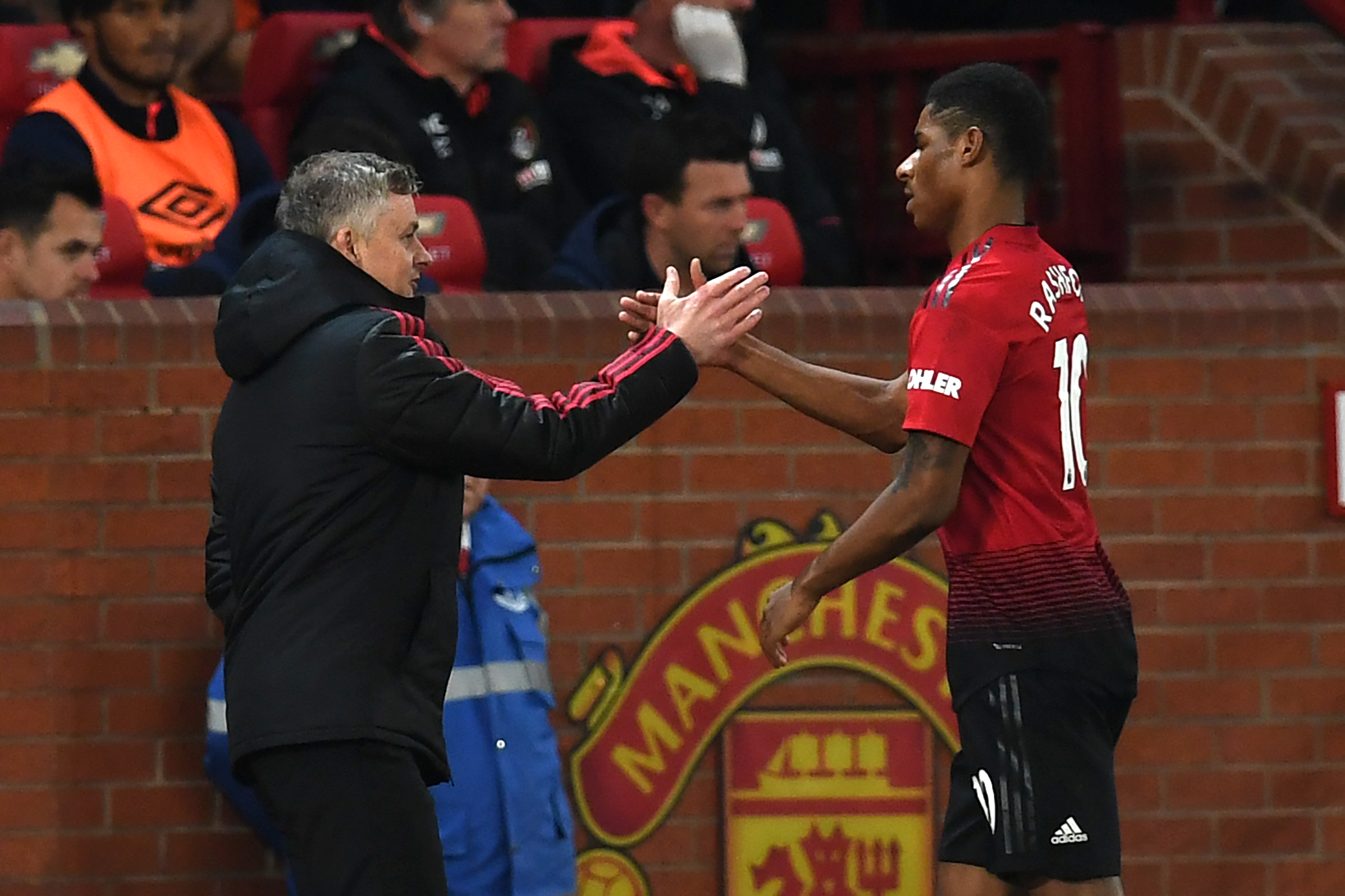 Manchester United's English striker Marcus Rashford (R) shakes hands with Manchester United's Norwegian caretaker manager Ole Gunnar Solskjaer (L) after being substituted during the English Premier League football match between Manchester United and Bournemouth at Old Trafford in Manchester, north west England, on December 30, 2018. (Photo by Paul ELLIS / AFP) / RESTRICTED TO EDITORIAL USE. No use with unauthorized audio, video, data, fixture lists, club/league logos or 'live' services. Online in-match use limited to 120 images. An additional 40 images may be used in extra time. No video emulation. Social media in-match use limited to 120 images. An additional 40 images may be used in extra time. No use in betting publications, games or single club/league/player publications. /         (Photo credit should read PAUL ELLIS/AFP/Getty Images)