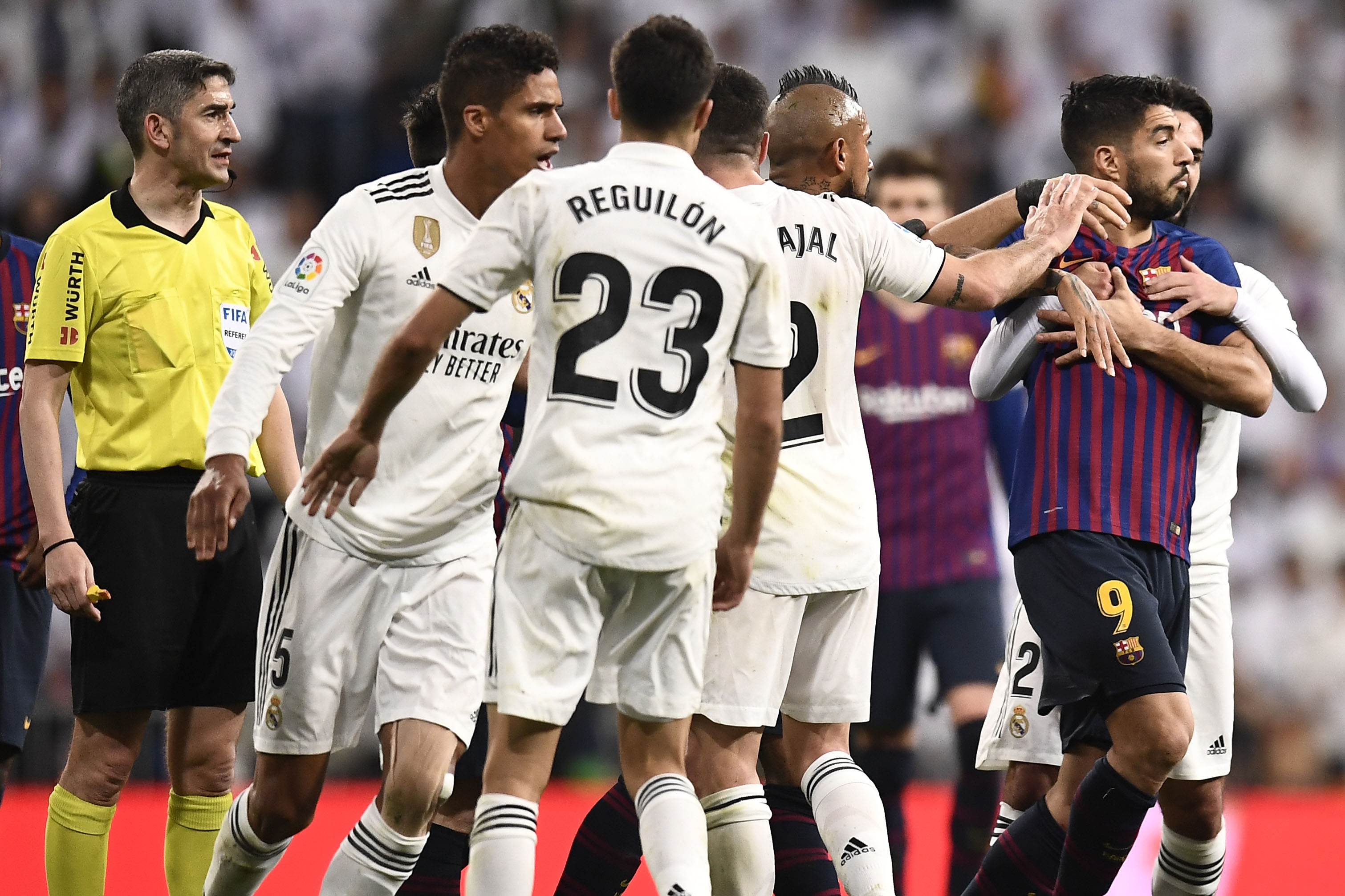 Barcelona's Uruguayan forward Luis Suarez (2R) is hold by Real Madrid's Spanish midfielder Isco (R) during the Spanish league football match between Real Madrid CF and FC Barcelona at the Santiago Bernabeu stadium in Madrid on March 2, 2019. (Photo by OSCAR DEL POZO / AFP)        (Photo credit should read OSCAR DEL POZO/AFP/Getty Images)