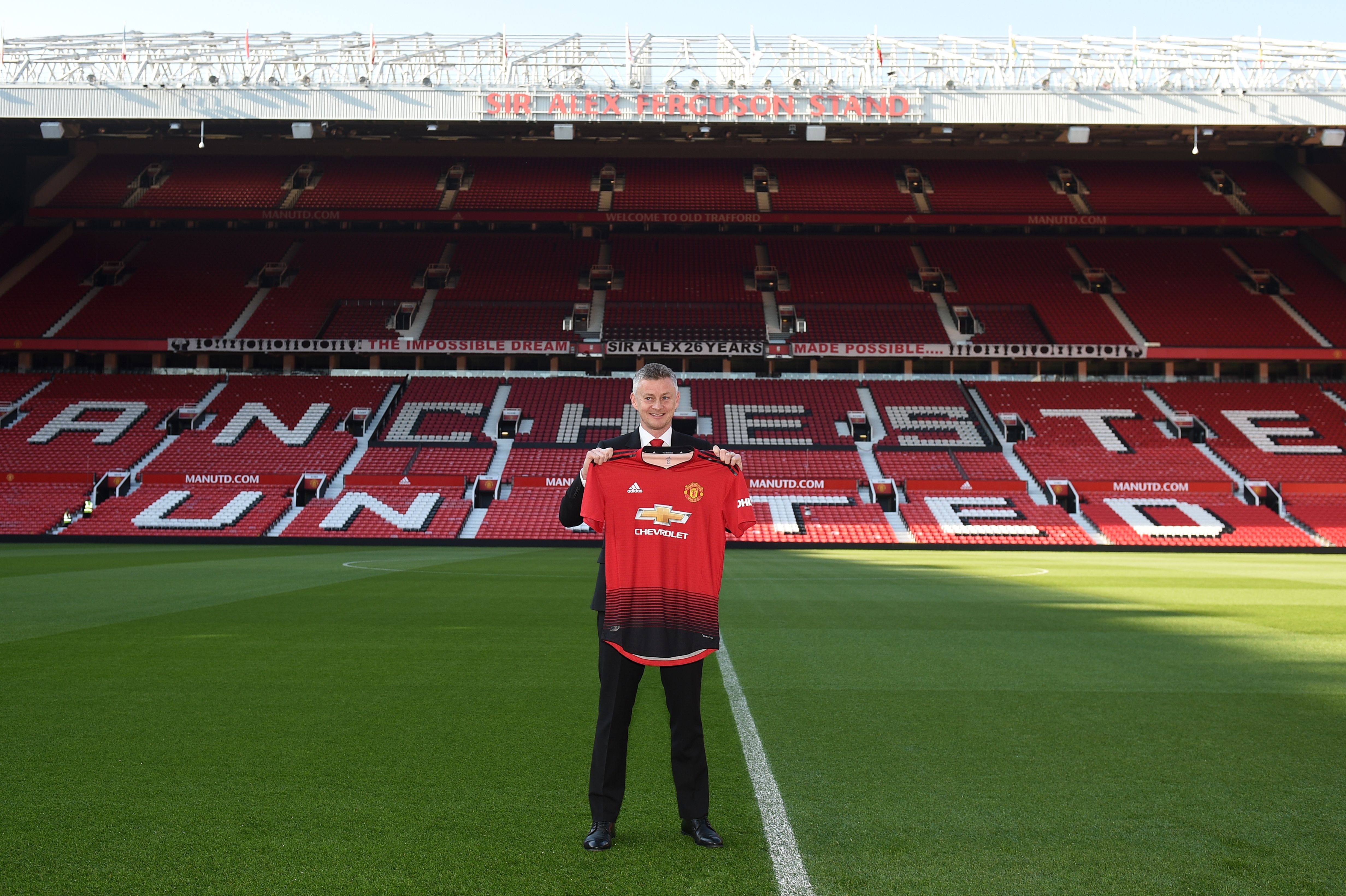 Manchester United's Norwegian manager Ole Gunnar Solskjaer poses with a team jersey during a photo call at Old Trafford in Manchester, northwest England, on March 28, 2019 after it was announced that he was appointed as the clubs full-time manager on a three-year contract. - Ole Gunnar Solskjaer said he was "beyond excited" to be handed the Manchester United manager's job on a full-time basis as the club announced on Thursday he had signed a three-year deal. (Photo by Oli SCARFF / AFP) / RESTRICTED TO EDITORIAL USE. No use with unauthorized audio, video, data, fixture lists, club/league logos or 'live' services. Online in-match use limited to 75 images, no video emulation. No use in betting, games or single club/league/player publications. /         (Photo credit should read OLI SCARFF/AFP/Getty Images)