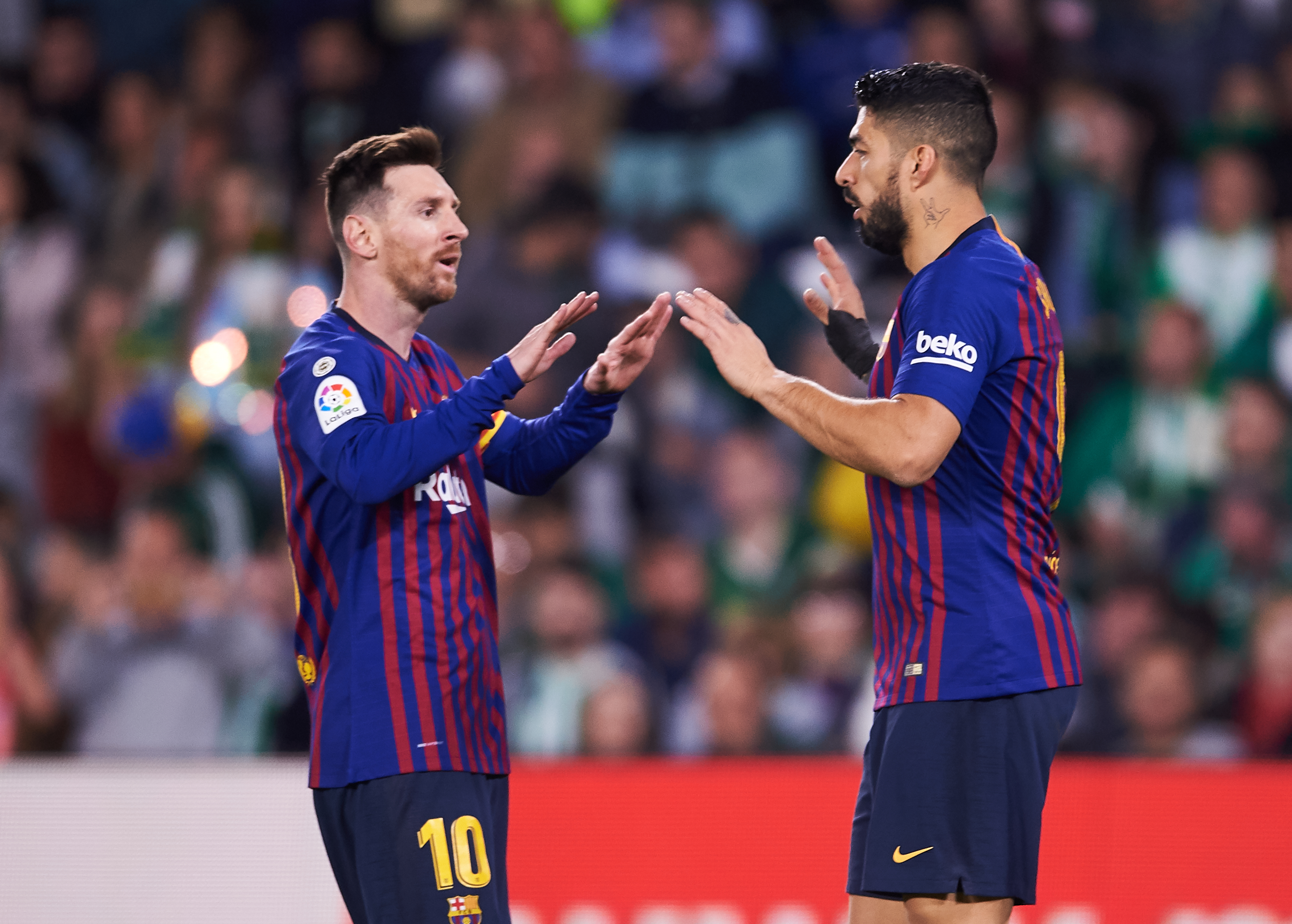 SEVILLE, SPAIN - MARCH 17: Luis Suarez of FC Barcelona celebrates with his teammates Lionel Messi of FC Barcelona after scoring his team's third goal during the La Liga match between Real Betis Balompie and FC Barcelona at Estadio Benito Villamarin on March 17, 2019 in Seville, Spain. (Photo by Aitor Alcalde/Getty Images)