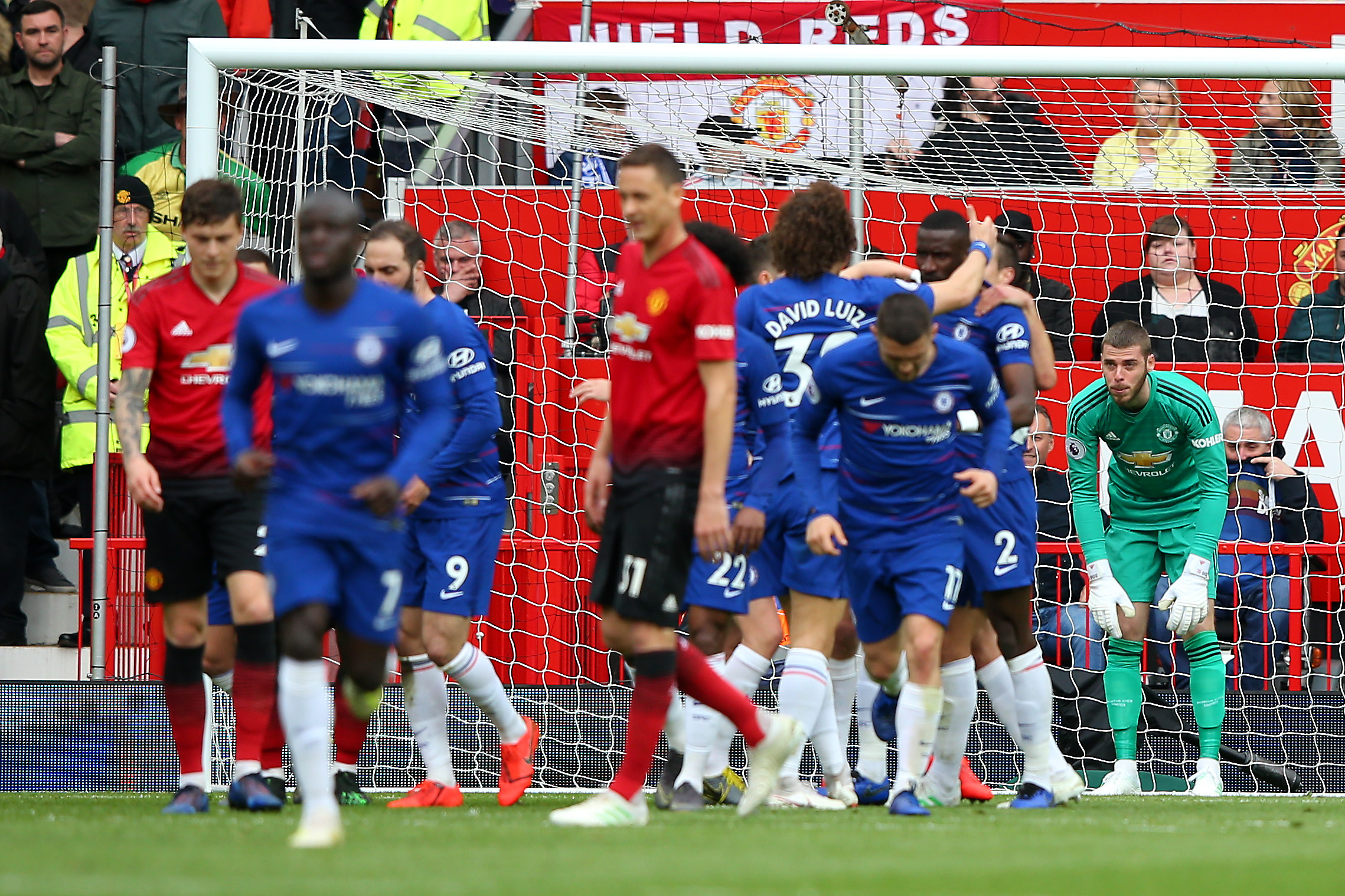 MANCHESTER, ENGLAND - APRIL 28:  David De Gea of Manchester United (R) looks dejected as Marcos Alonso of Chelsea celebrates scoring their first goal with team mates during the Premier League match between Manchester United and Chelsea FC at Old Trafford on April 28, 2019 in Manchester, United Kingdom. (Photo by Alex Livesey/Getty Images)